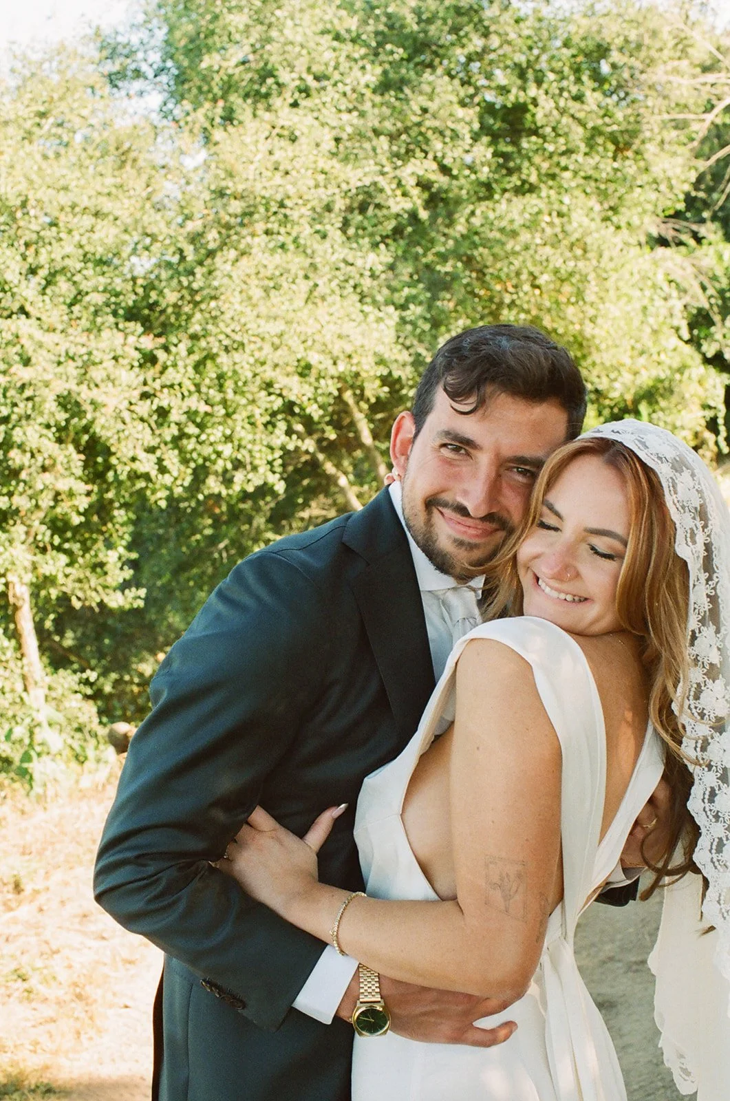 Bride and groom smile for portraits. Analog 35 mm film.