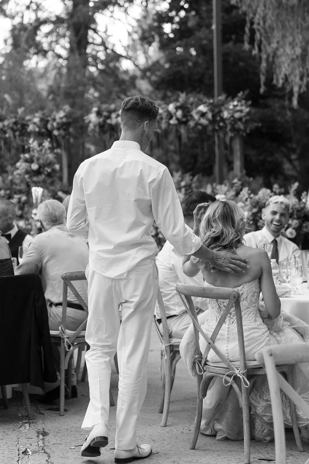 Bride and groom sit and chat with wedding guests at the outdoor wedding reception in Big Bear California