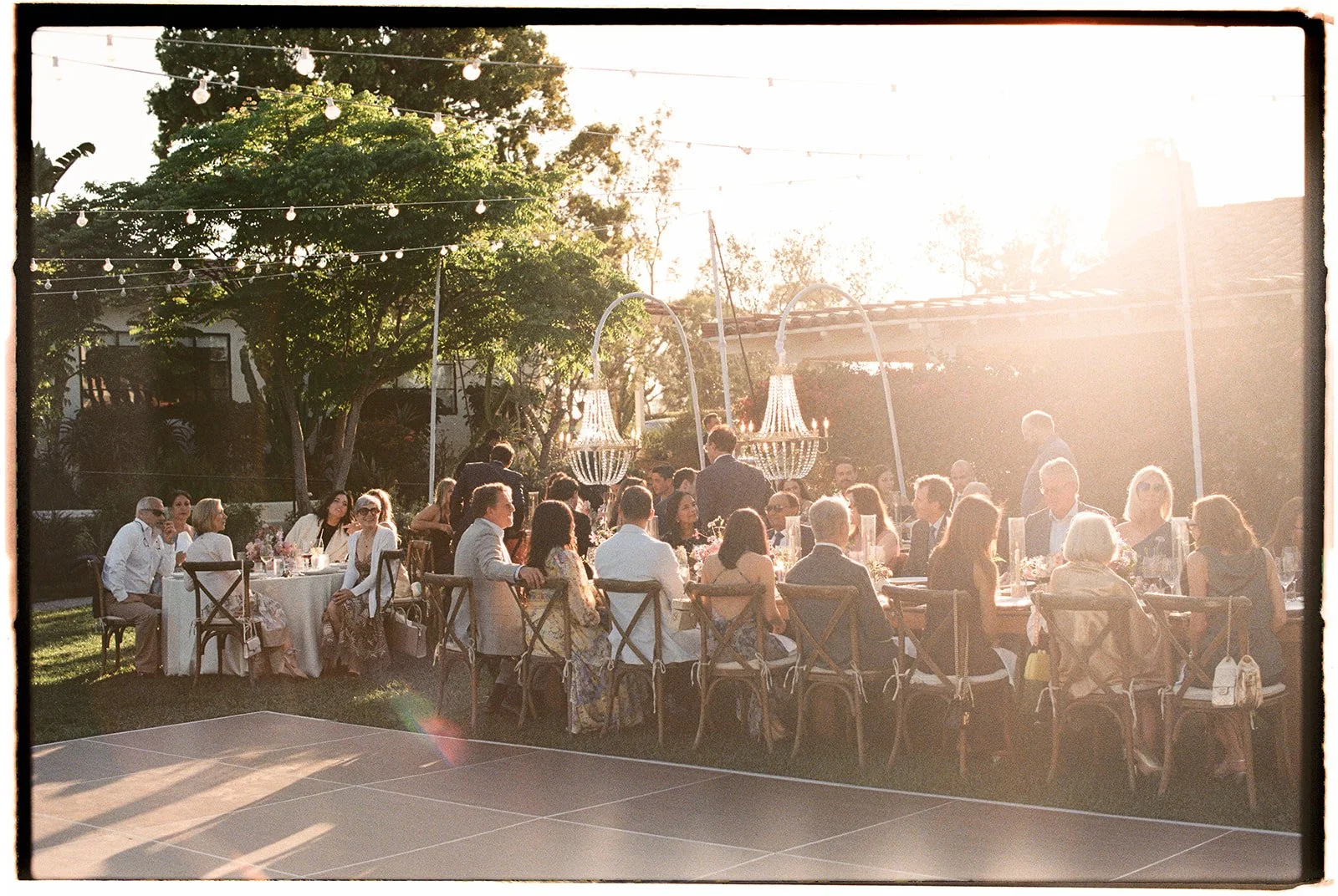  The sun setting as the wedding guests sit for dinner and look forward to the arrival of the bride and groom. 35 mm film. 