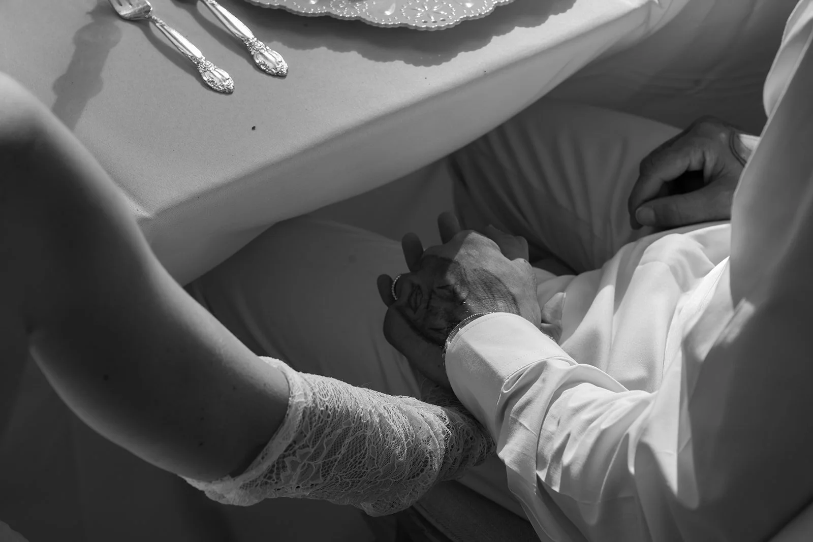 Bride and Groom hold hands under the table during the wedding dinner in Big Bear California