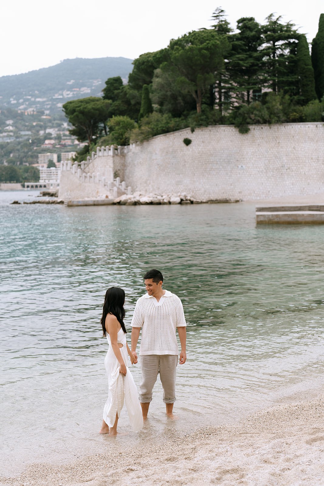 Beach engagement photo of the couple standing together in the Mediterranean Sea in the Rade de Villefranche