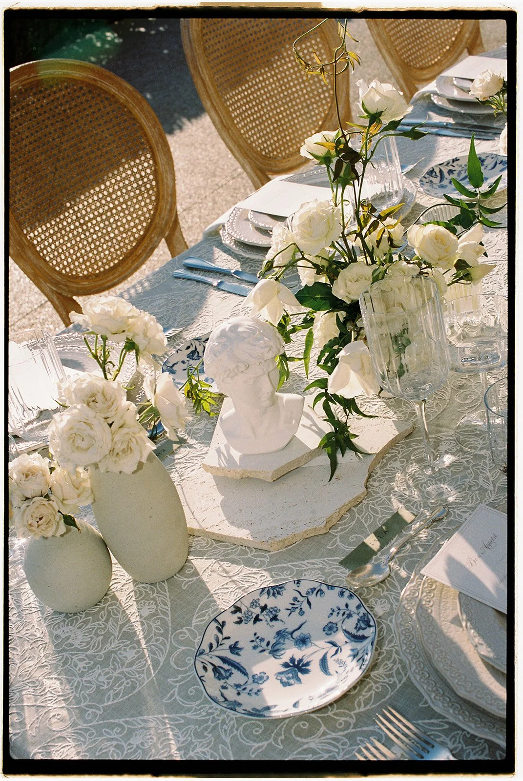 The reception details: floral centerpieces, sculptures, and blue china