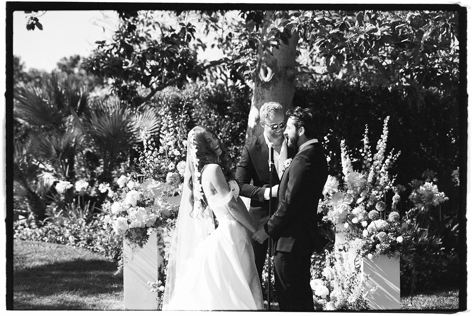  The bride and groom laughing during their wedding ceremony. 35 mm film. 