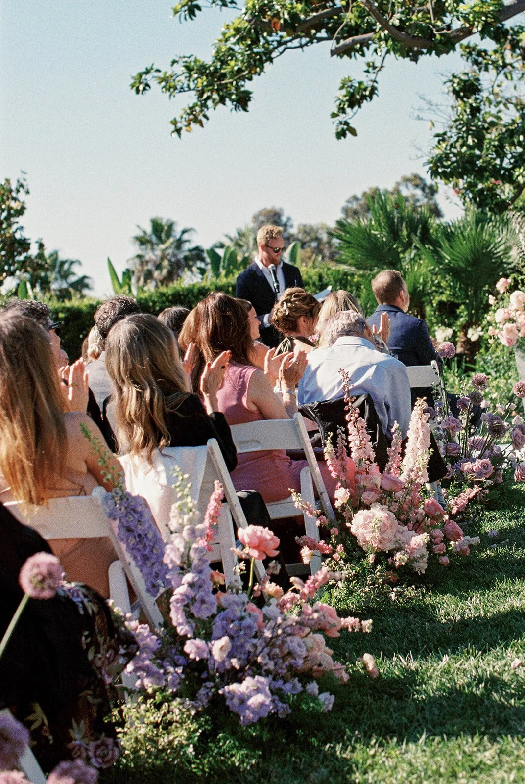 The wedding guests showing their love for the bride and groom surrounded by wedding flowers. 