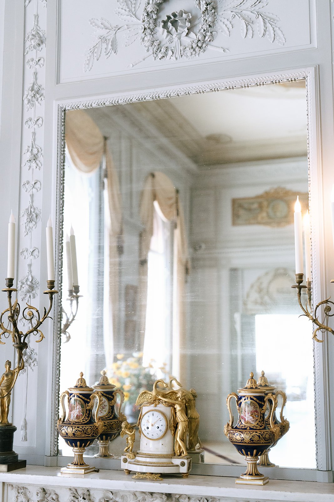 Details on a mantel including a clock, porcelain urns, and rococo candelabras inside the Villa Ephrussi de Rothschild