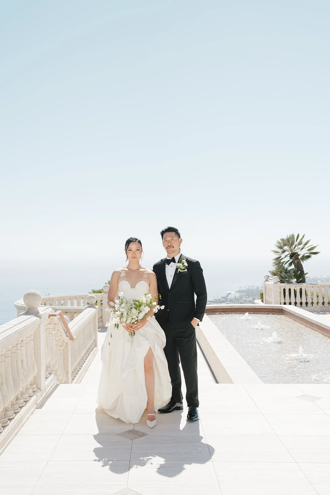 The bride and groom with the ocean behind.