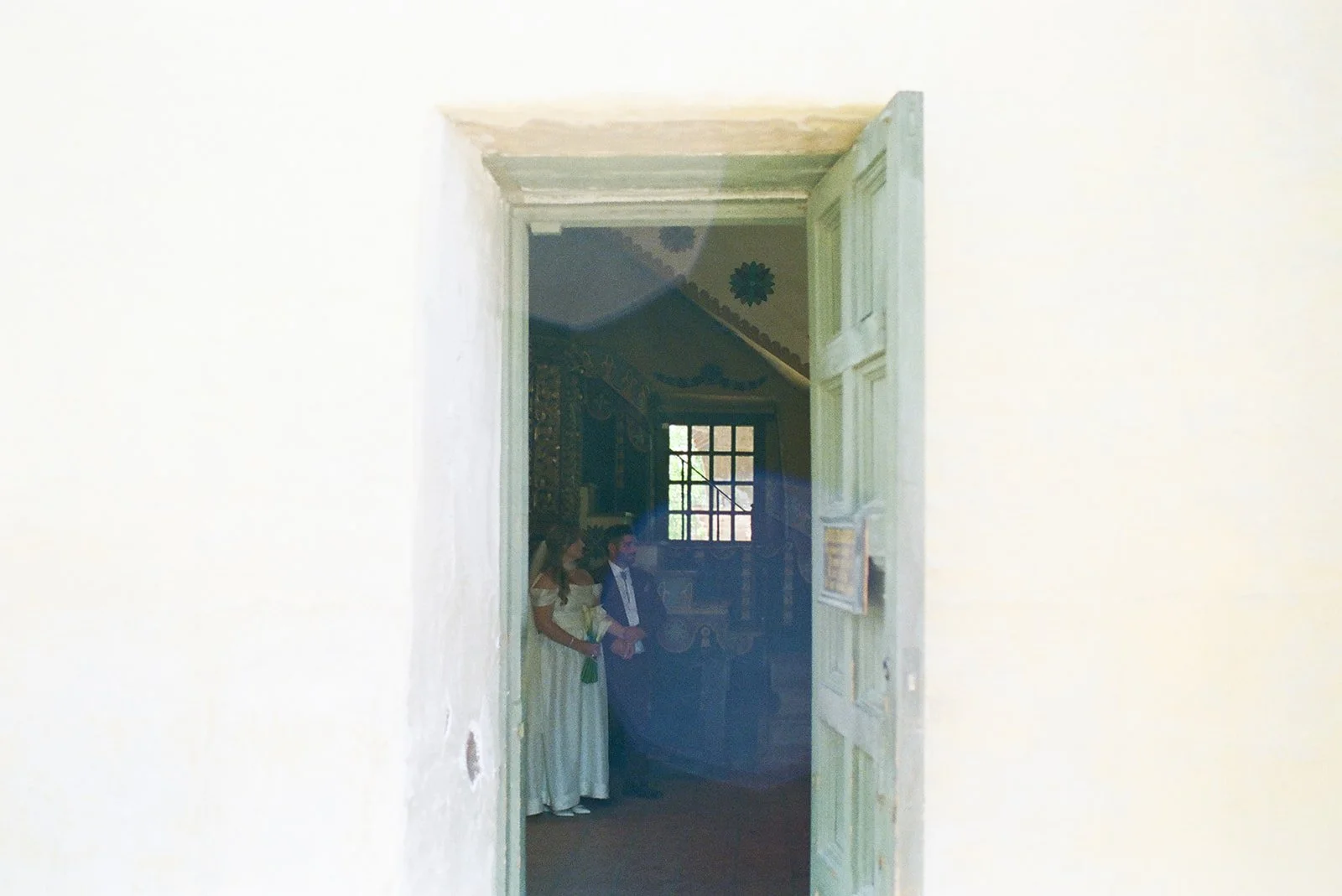 The happy couple participates in the traditional Catholic Wedding Mass. Analog 35 mm film.