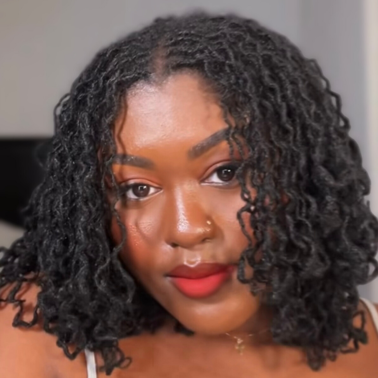 woman with microlocs and braid out curls