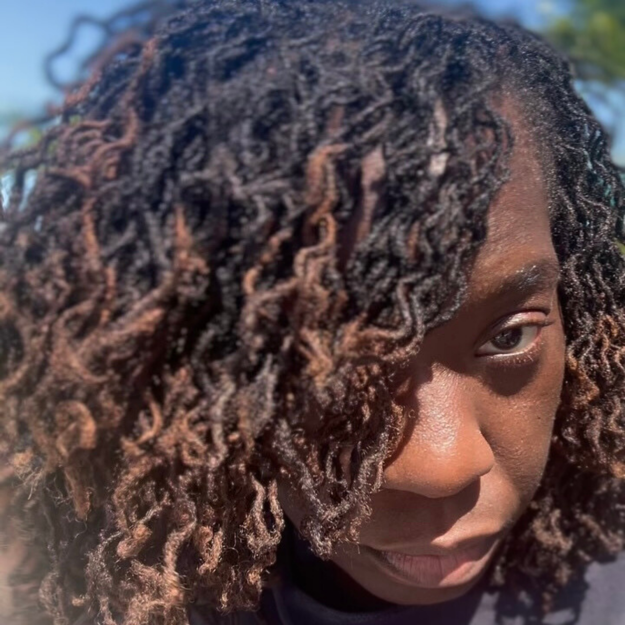 woman with microlocs and braid out curls