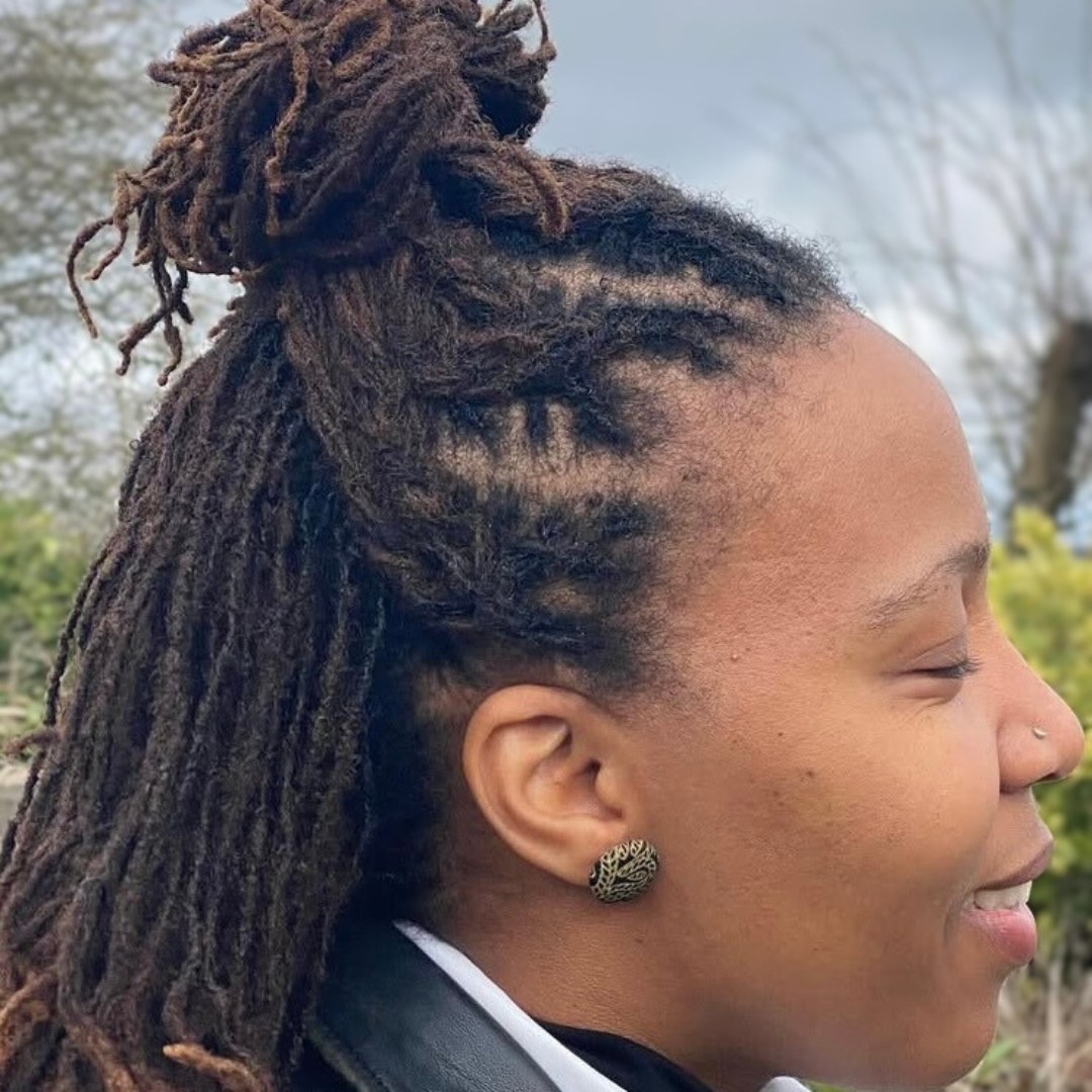 woman with mircolocs and braided half up top bun
