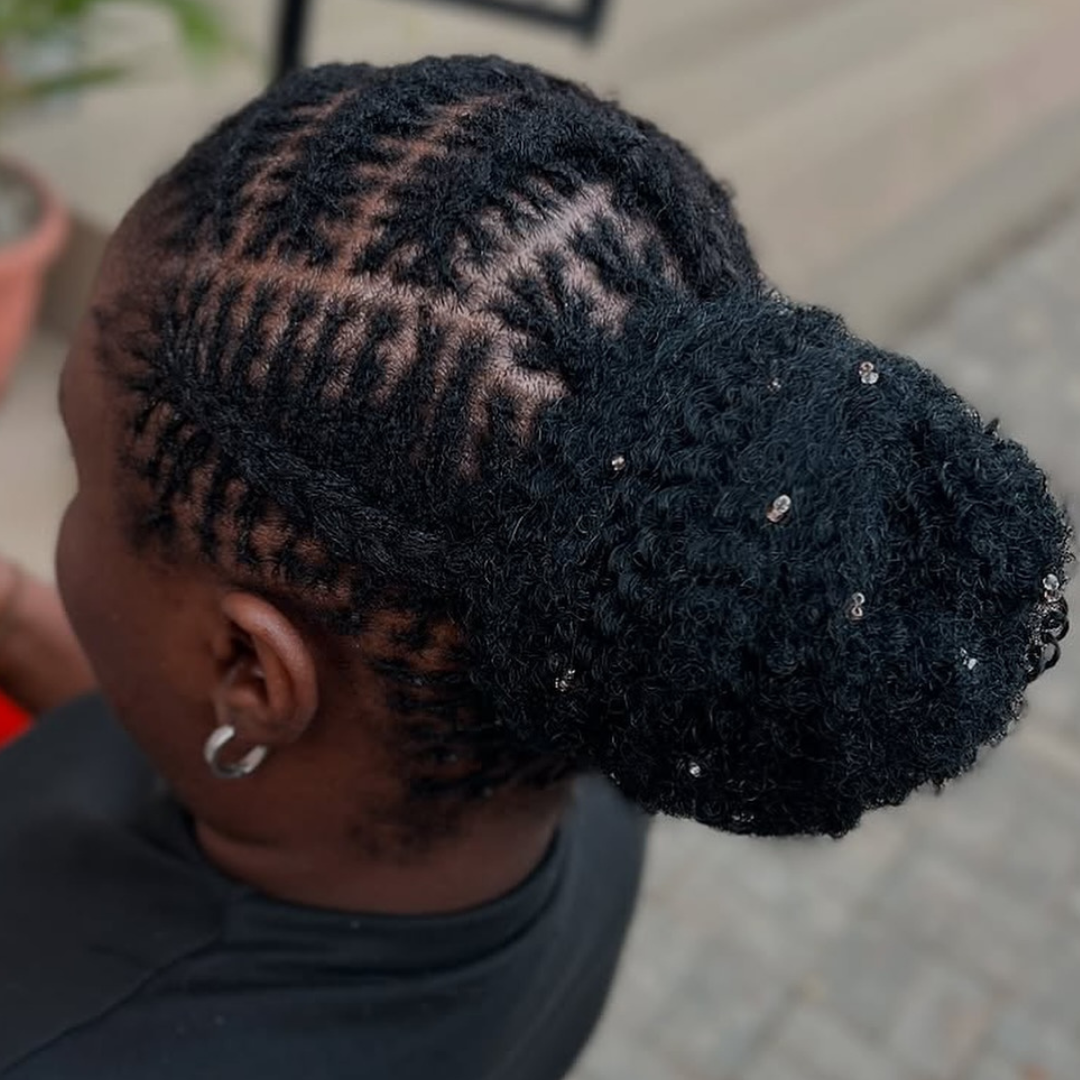 woman with microlocs cornrows and a bun