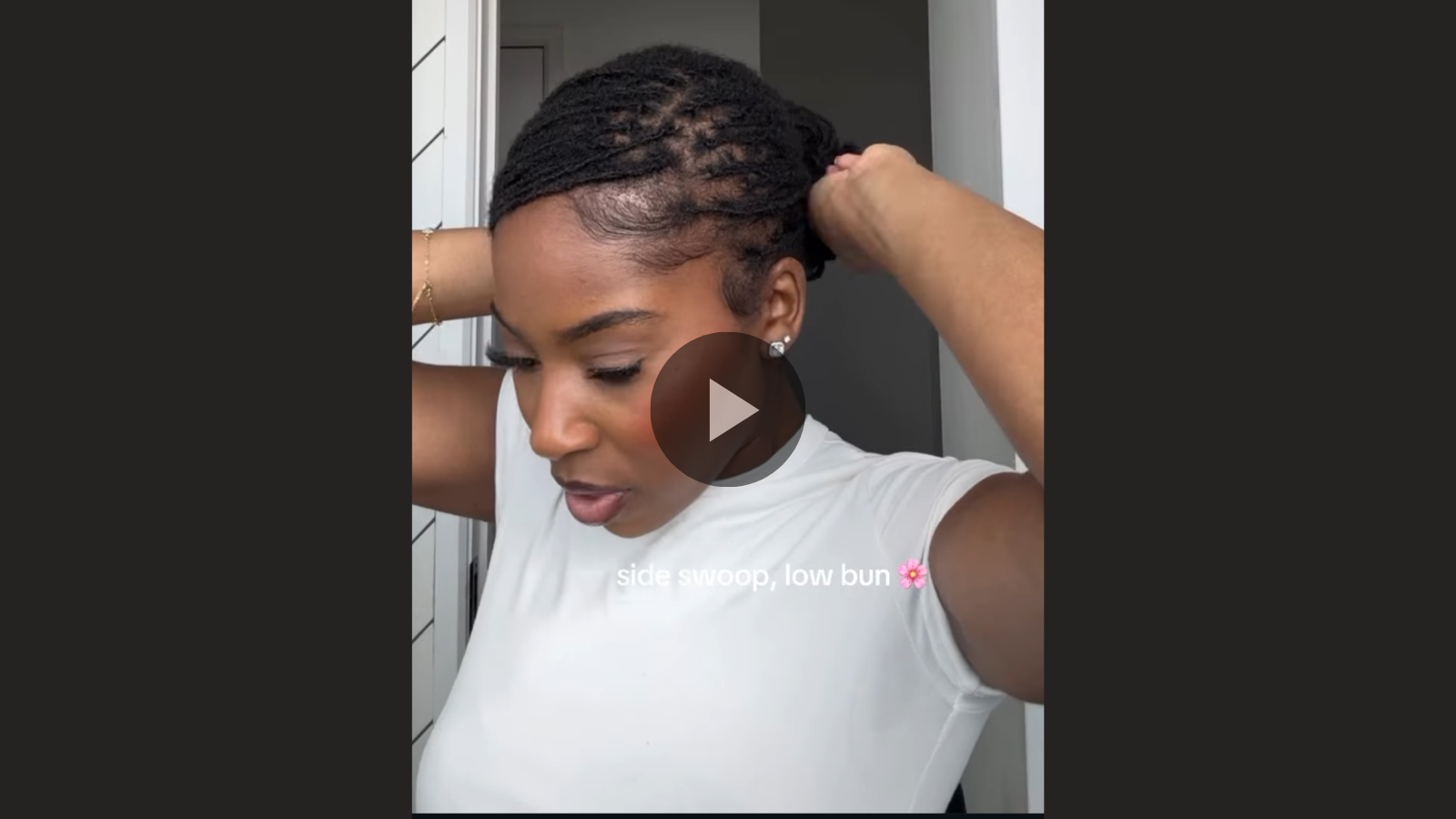 woman with microlocs and side swoop bang and bun