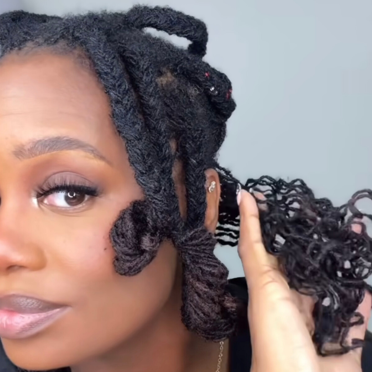 woman with microlocs and braid out curls