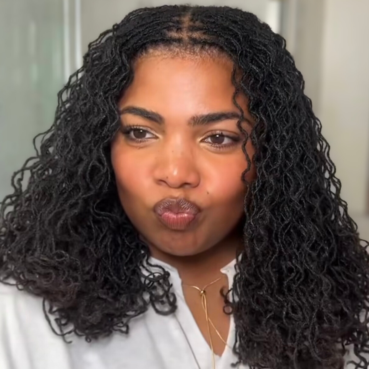 woman with microlocs and braid out curls