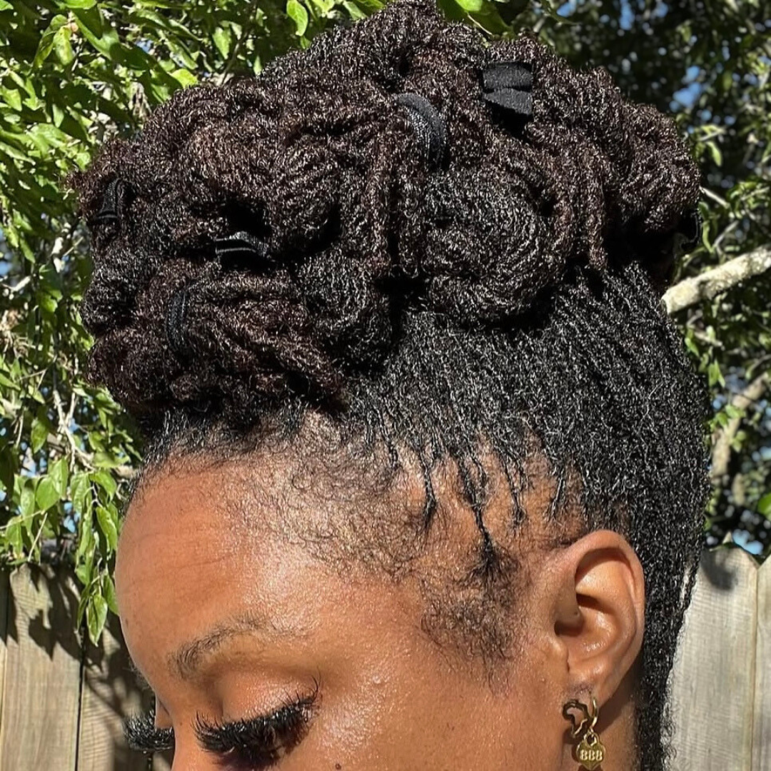 woman with microlocs and twisted top knot bun