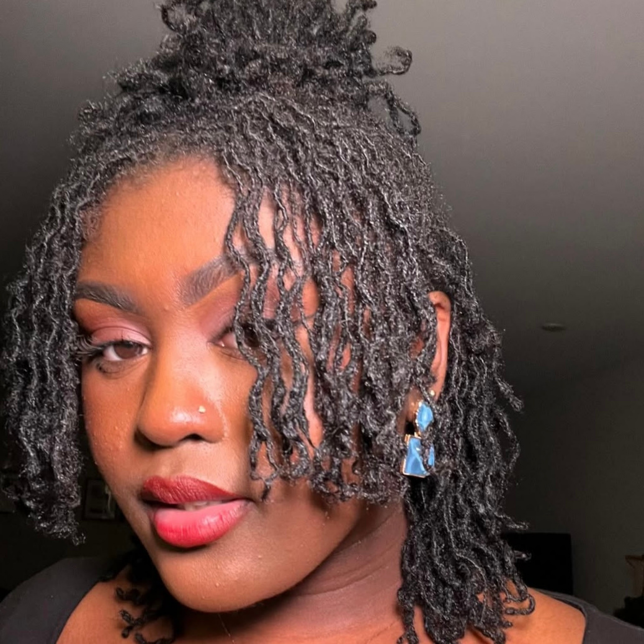 woman with microlocs and braid out curls