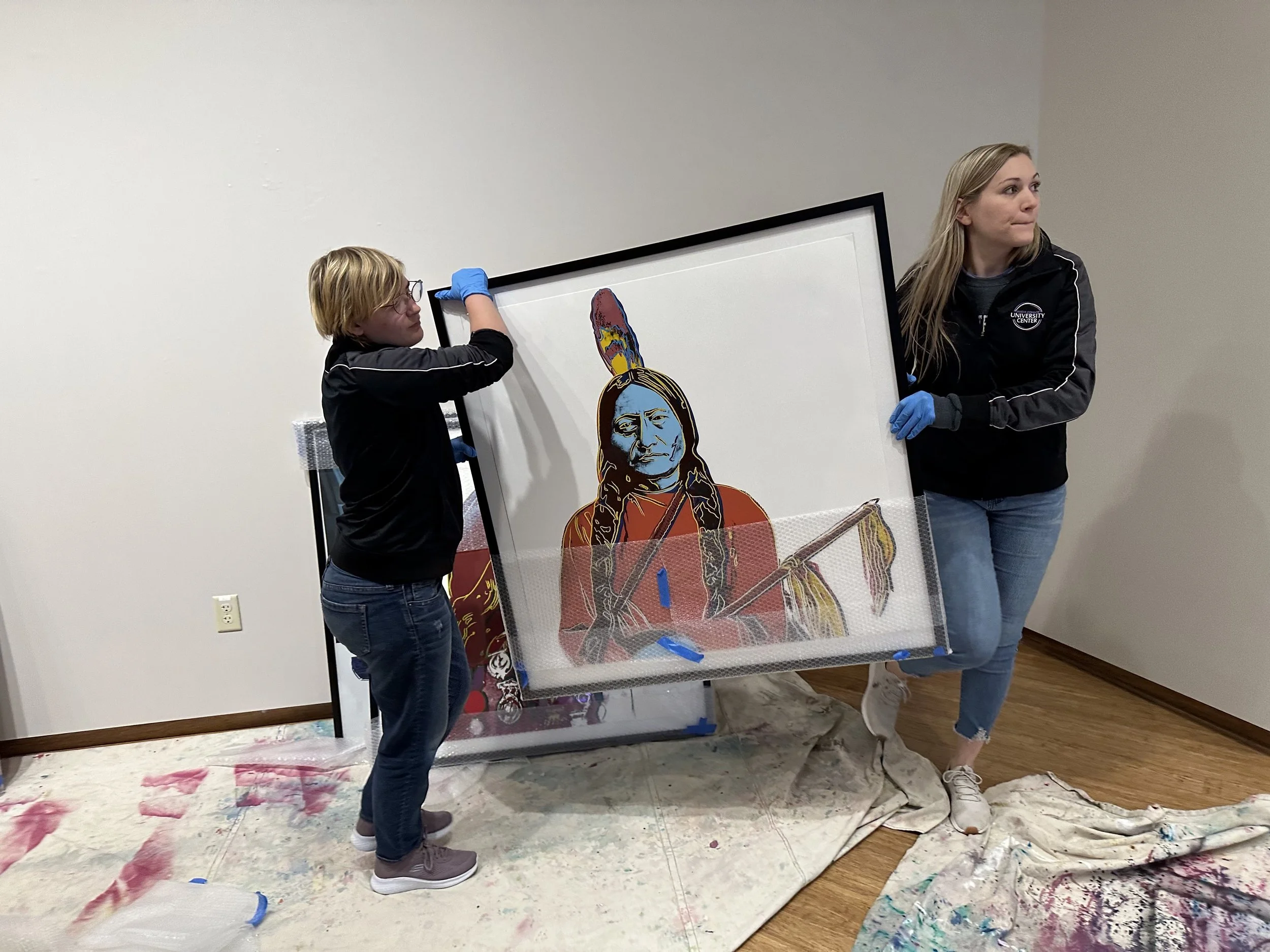 Veena Johnson helping install artwork at Roberta’s Art Gallery