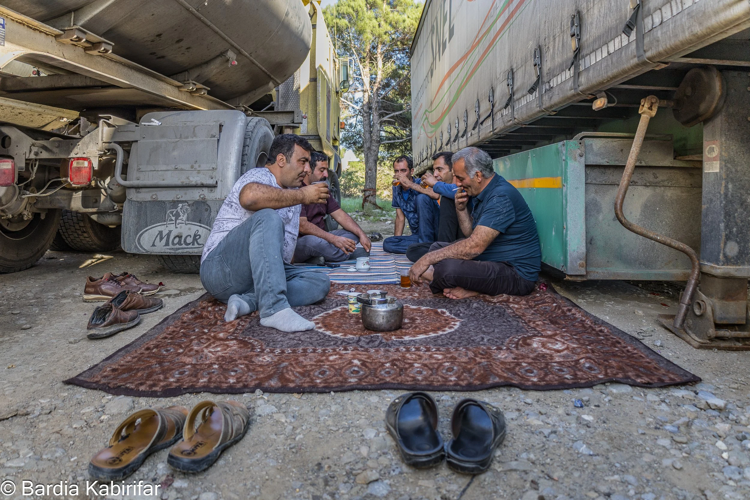 A group of Iranian truck drivers drinking tea in a truck parking spot on the outskirts of Tbilisi. They delivered oil products from Iran and will depart the following day. For Iran, as a country under heavy sanctions, any possible trade route is vita