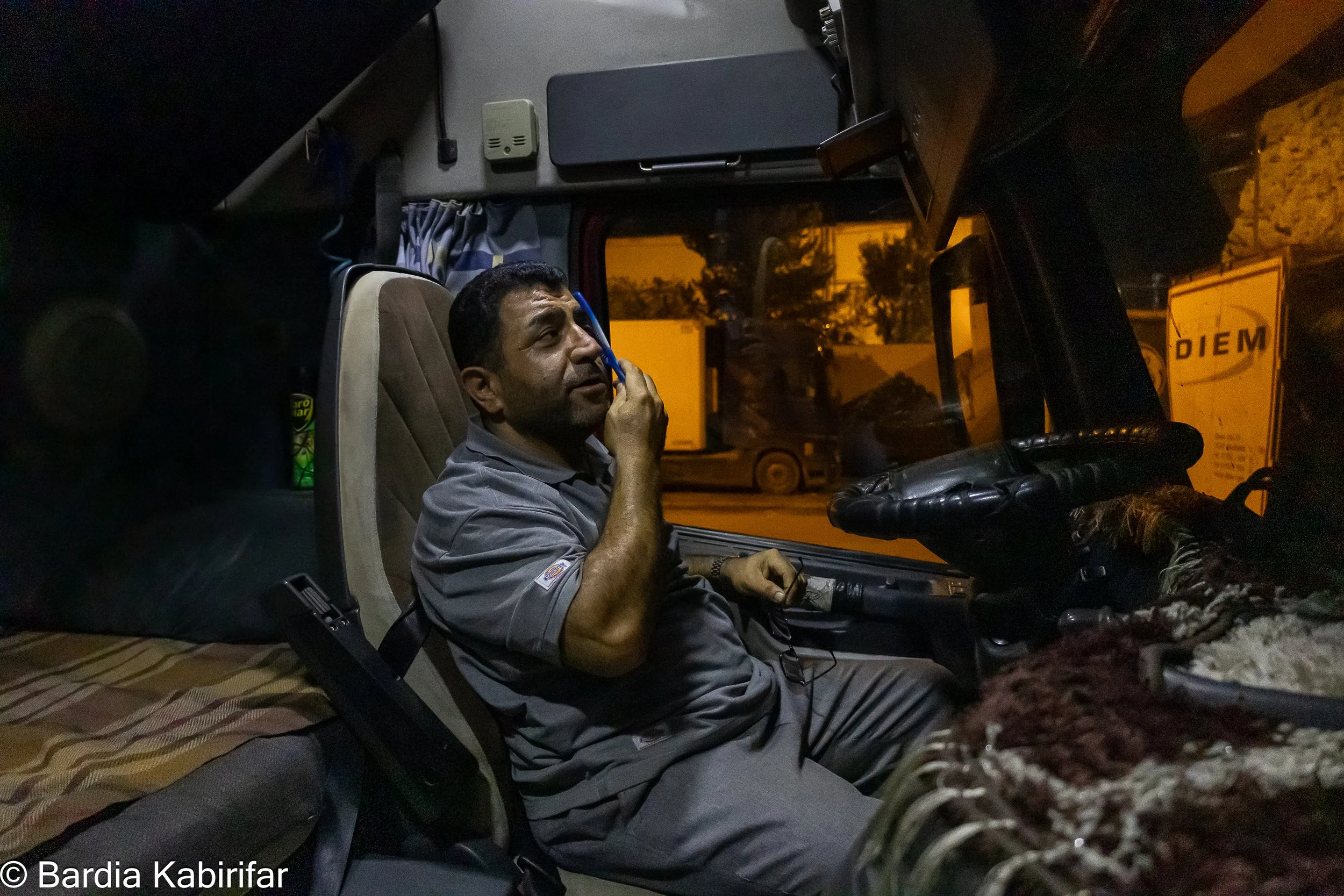 Tbilisi, Georgia - Ismail combing his hair before going to bed. Truck not only works as a work space but also as a home for drivers. From bed to storage space and fridge, everything must be fit here. (October 2nd, 2023 Tbilisi, Georgia)