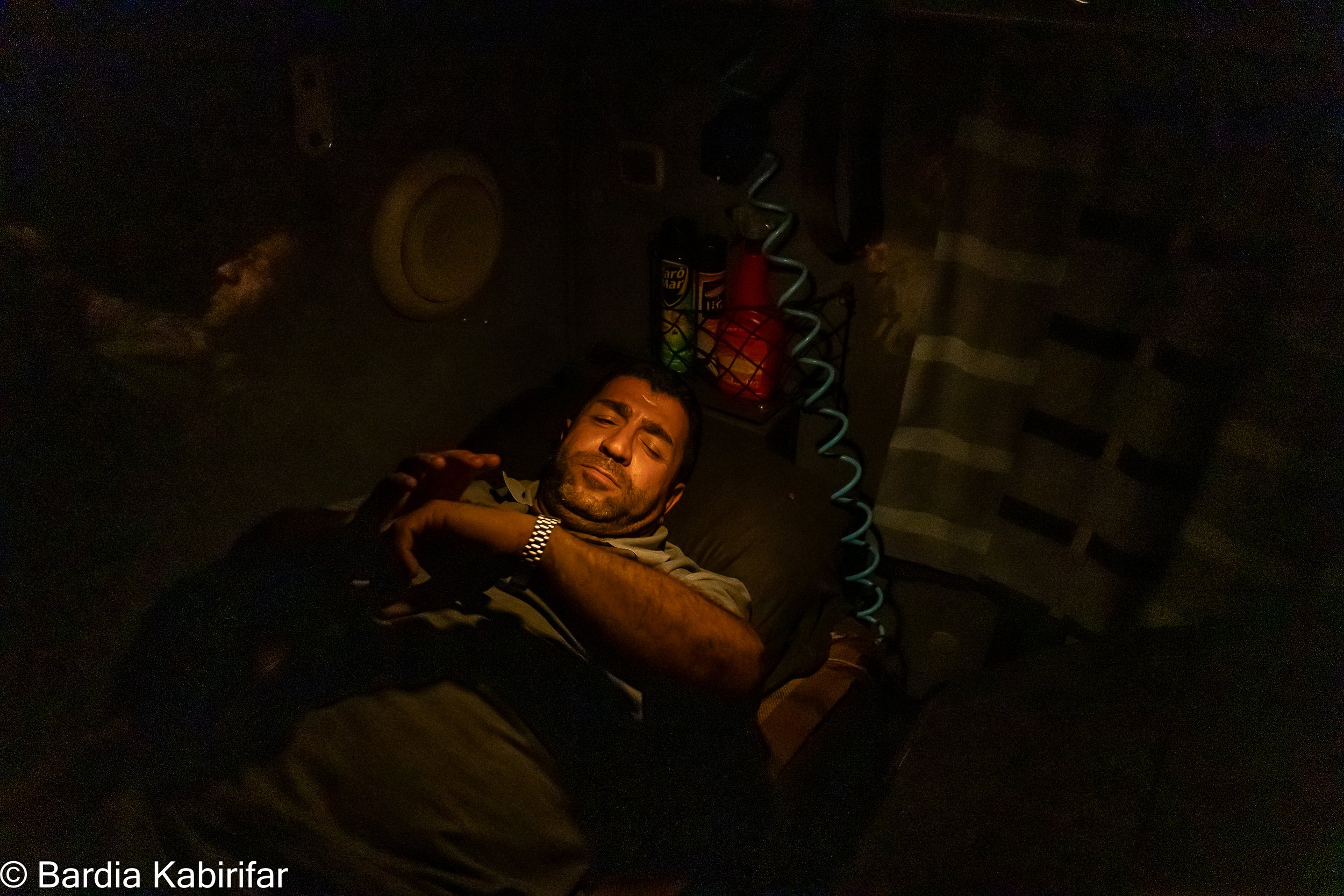 Ismail going to bed after a long day. Truck not only works as a work space but also as a home for drivers. From bed to storage space and fridge, everything must be fit here. (October 2nd, 2023 Tbilisi, Georgia)