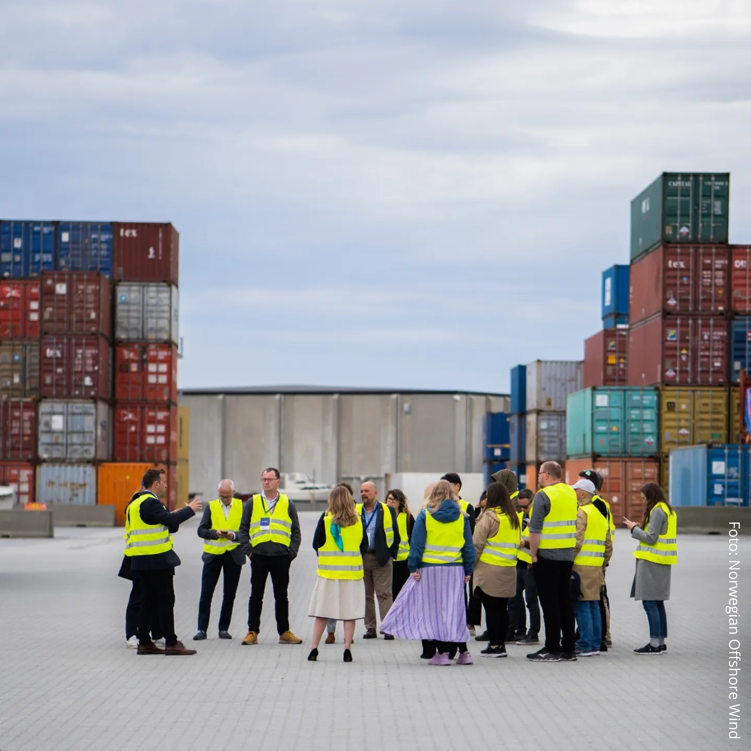 Norwegian Offshore Wind. Samling av personer med gule vester på et industriområde