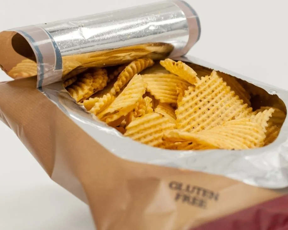 Open bag of potato chips showing ridged, golden chips inside.