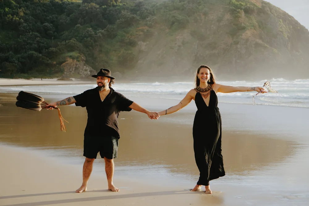 Omora and Sophie holding hands by the ocean