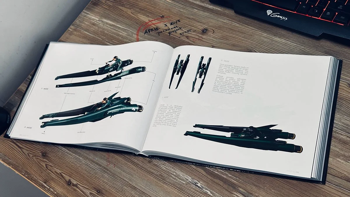 Open book displaying detailed technical illustrations of a futuristic spaceship or aircraft design on a wooden desk.