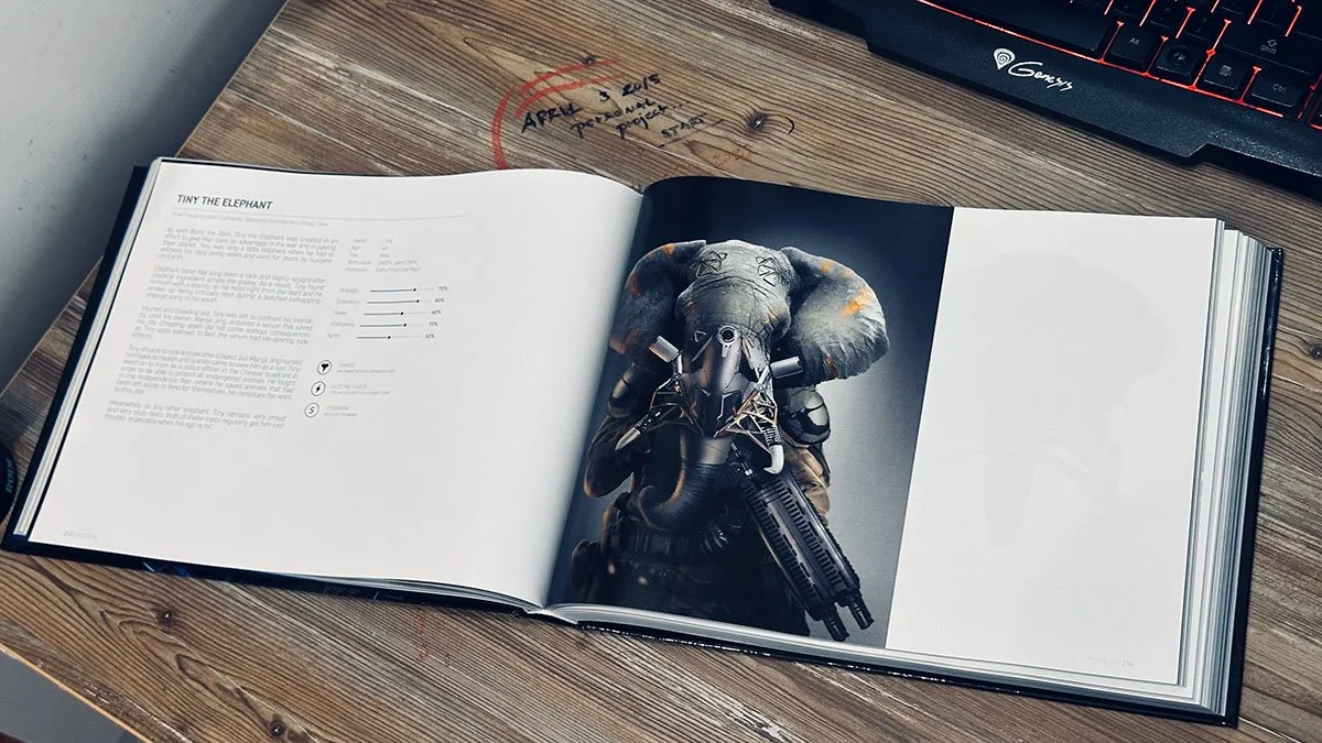 Open book on a wooden desk showing a page with text about tiny elephants and a photograph of a person wearing an elephant mask and military gear holding a firearm.