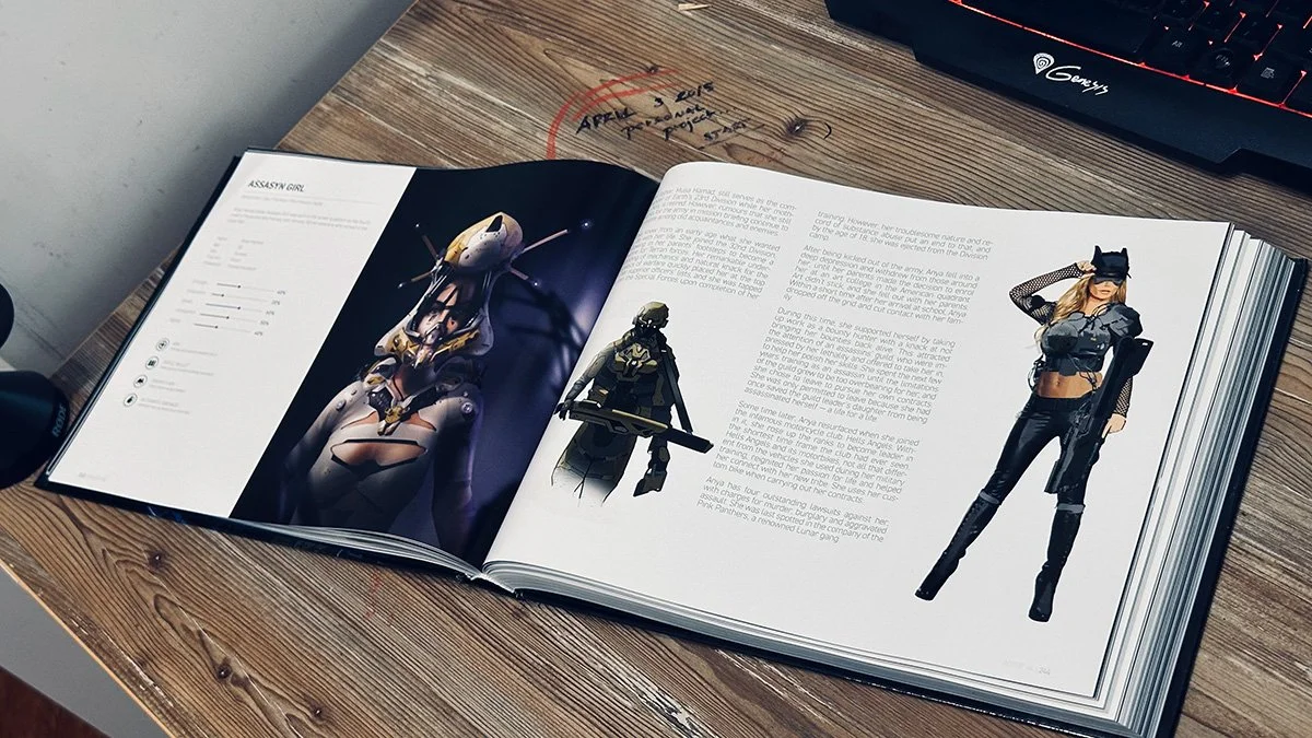 Open book on a wooden desk showing character images from video games or comics, including a robot, a soldier with a weapon, and a woman in armor and tactical gear, with a keyboard partially visible in the top right corner.