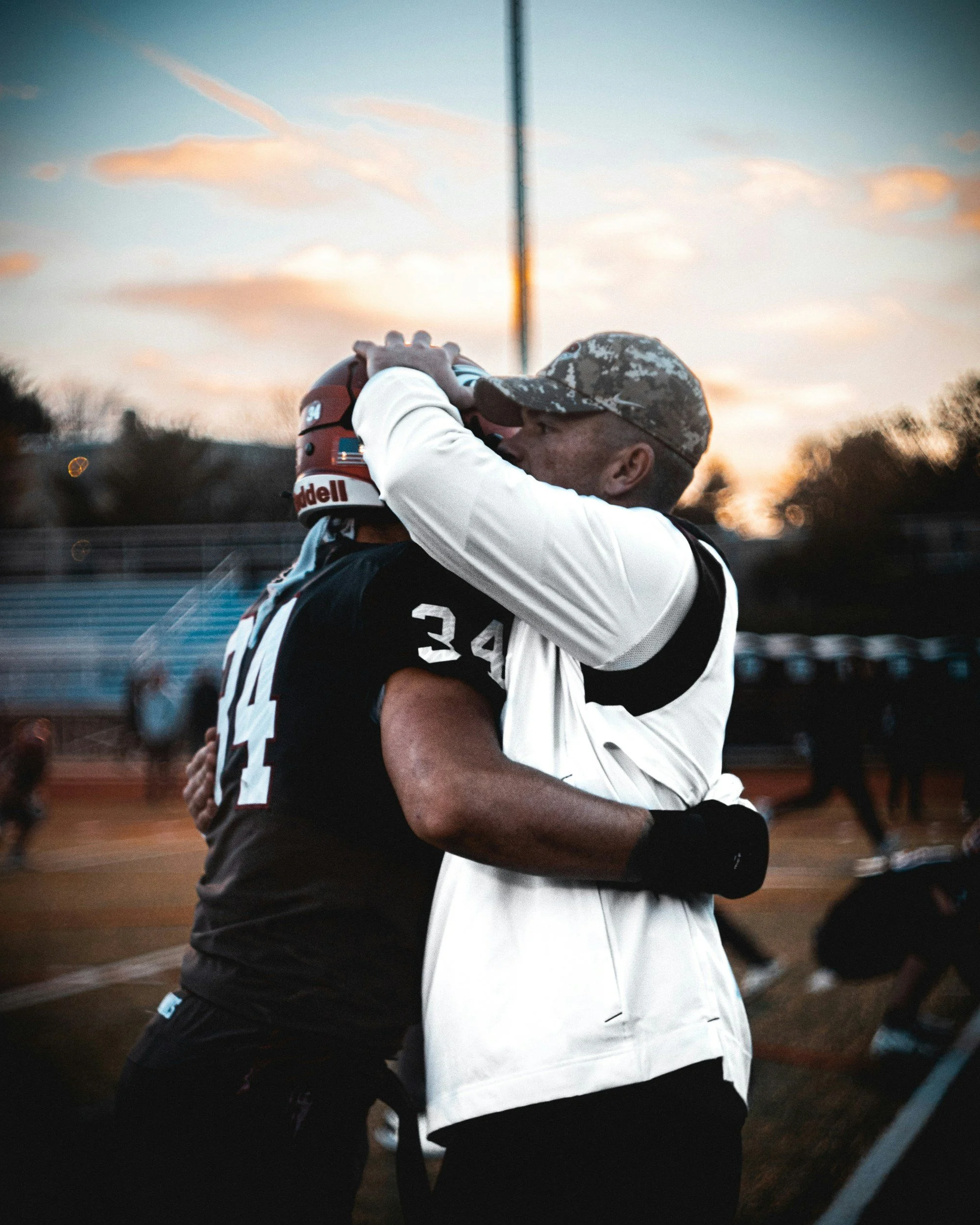 A coach supporting a football player