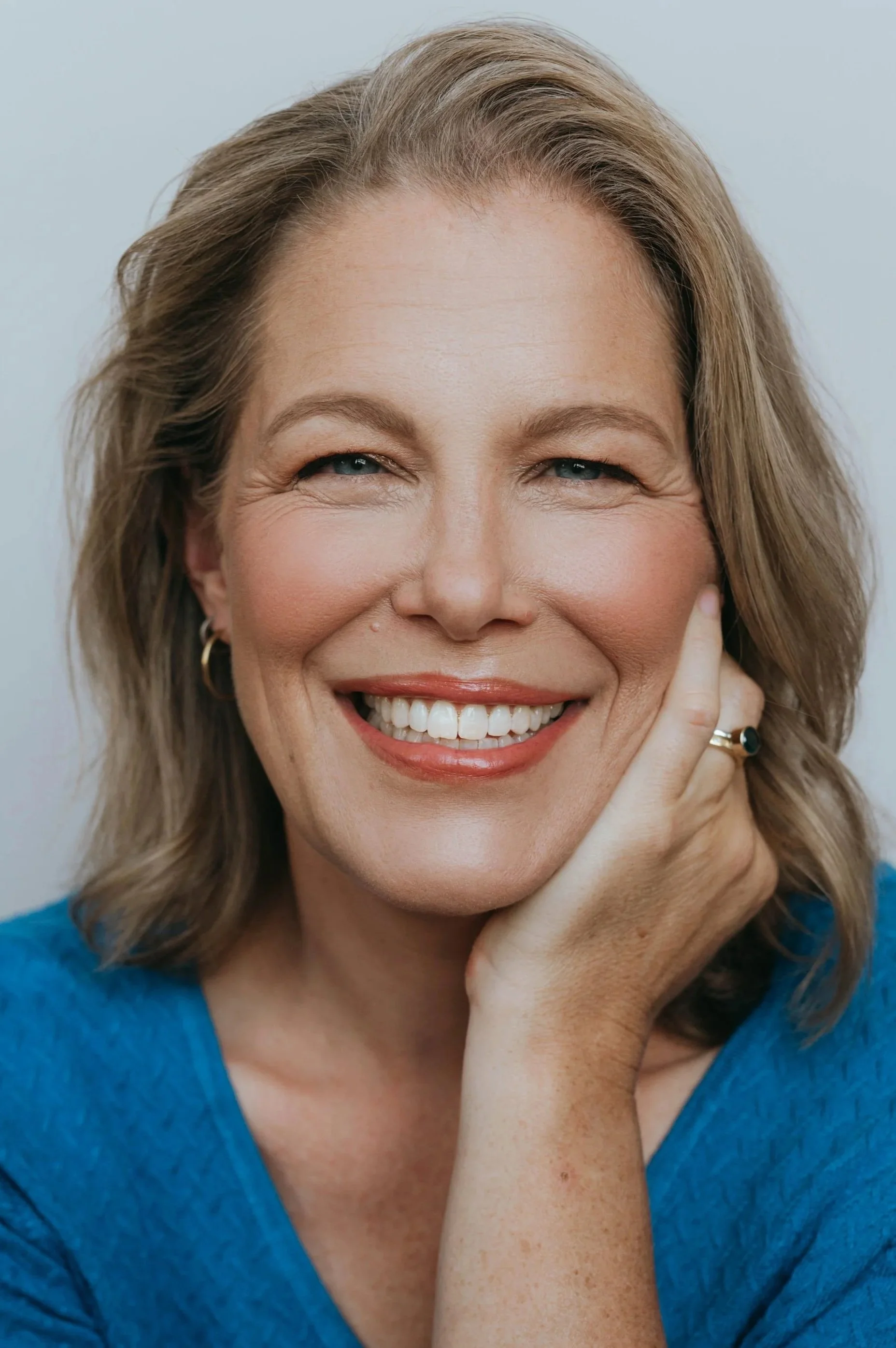 Headshot - woman looking at camera with blue sweater