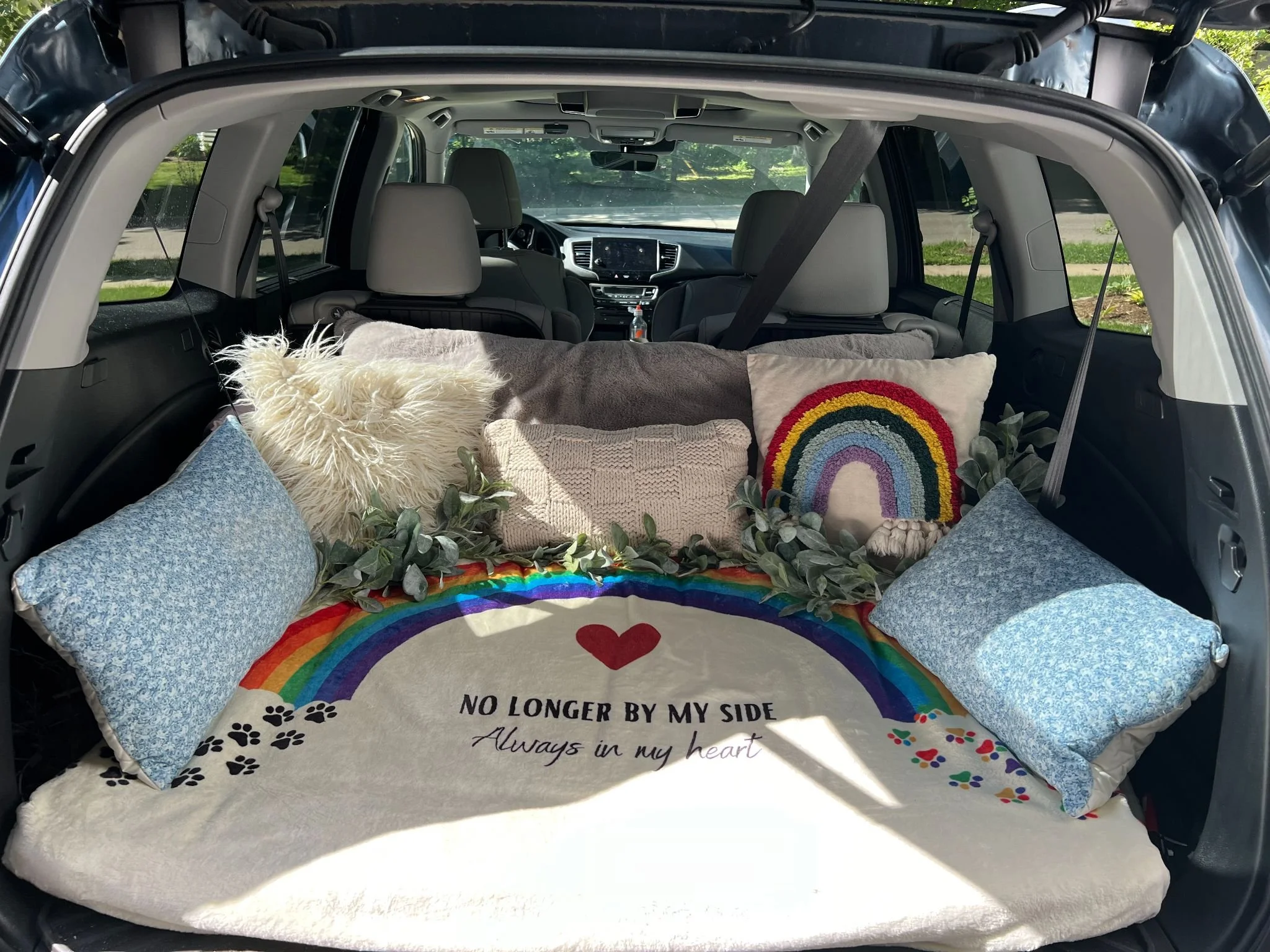 A cozy bed set up in the back of the car for your pet