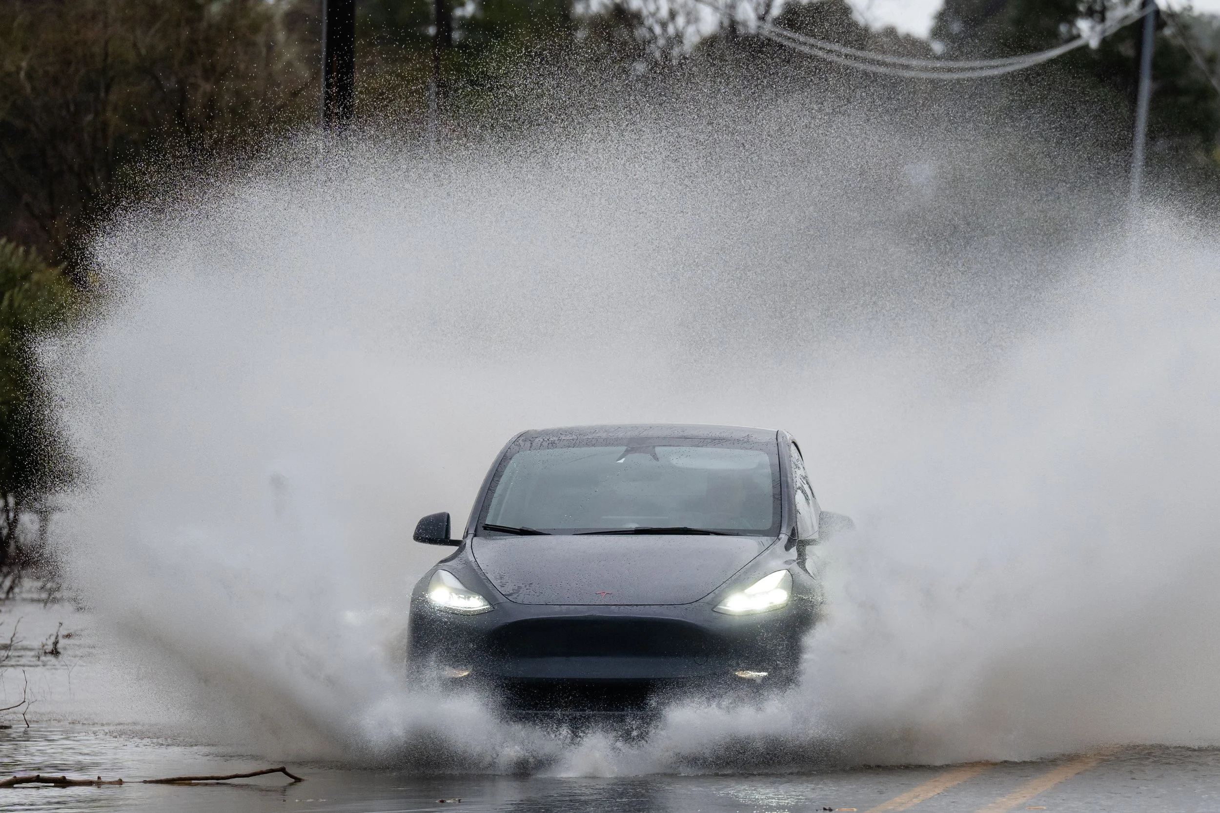 A motorist drives into a flooded section of Santa Teresa Boulevard in San Martin, Calif., on Thursday, February 13, 2025. | Thien-An Truong for Bay Area News Group
