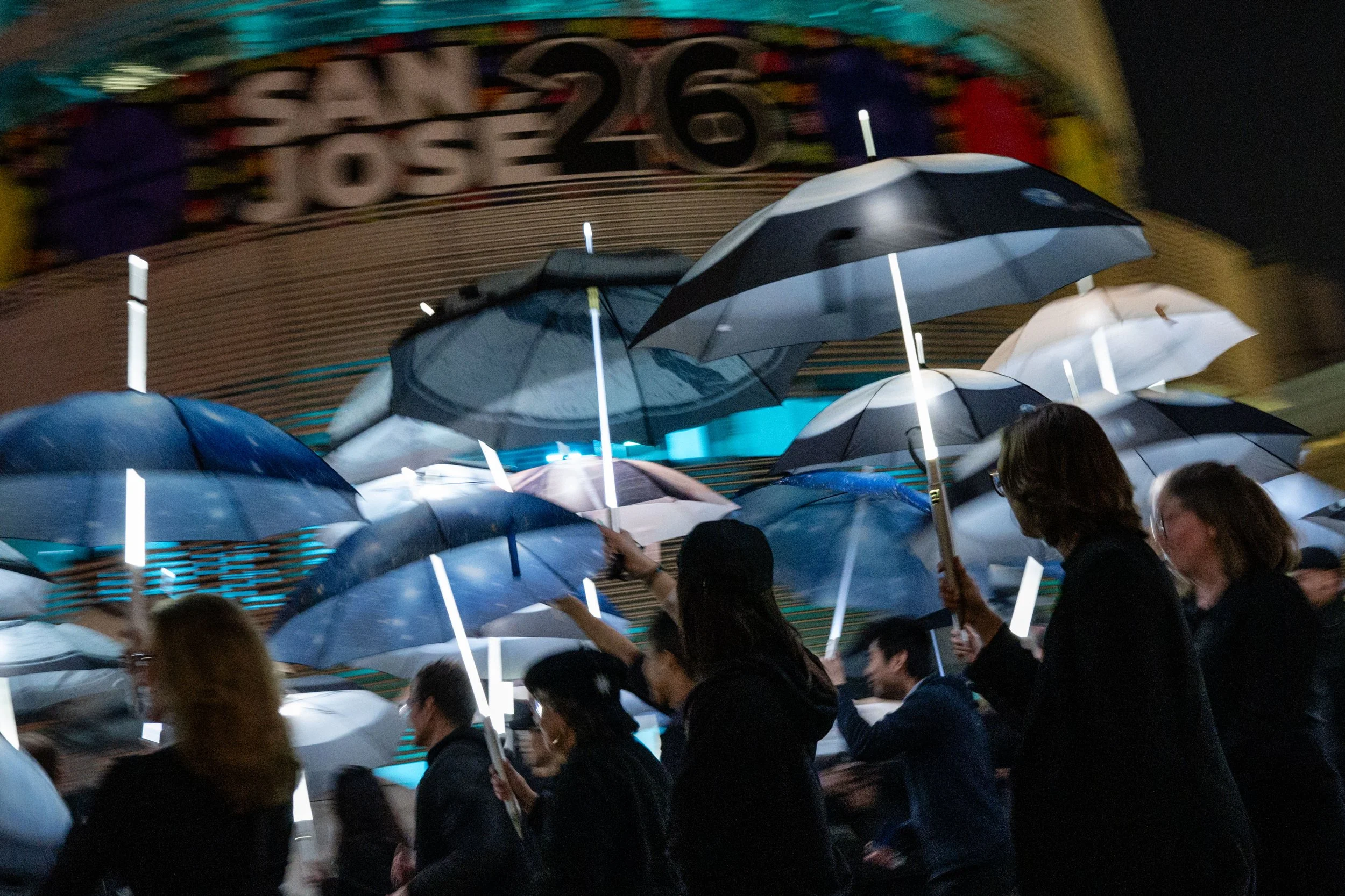Participants march with umbrellas printed with aerial photographs at City Hall in San Jose, Calif., on Saturday, Jan. 31, 2026. | Thien-An Truong for Bay Area News Group