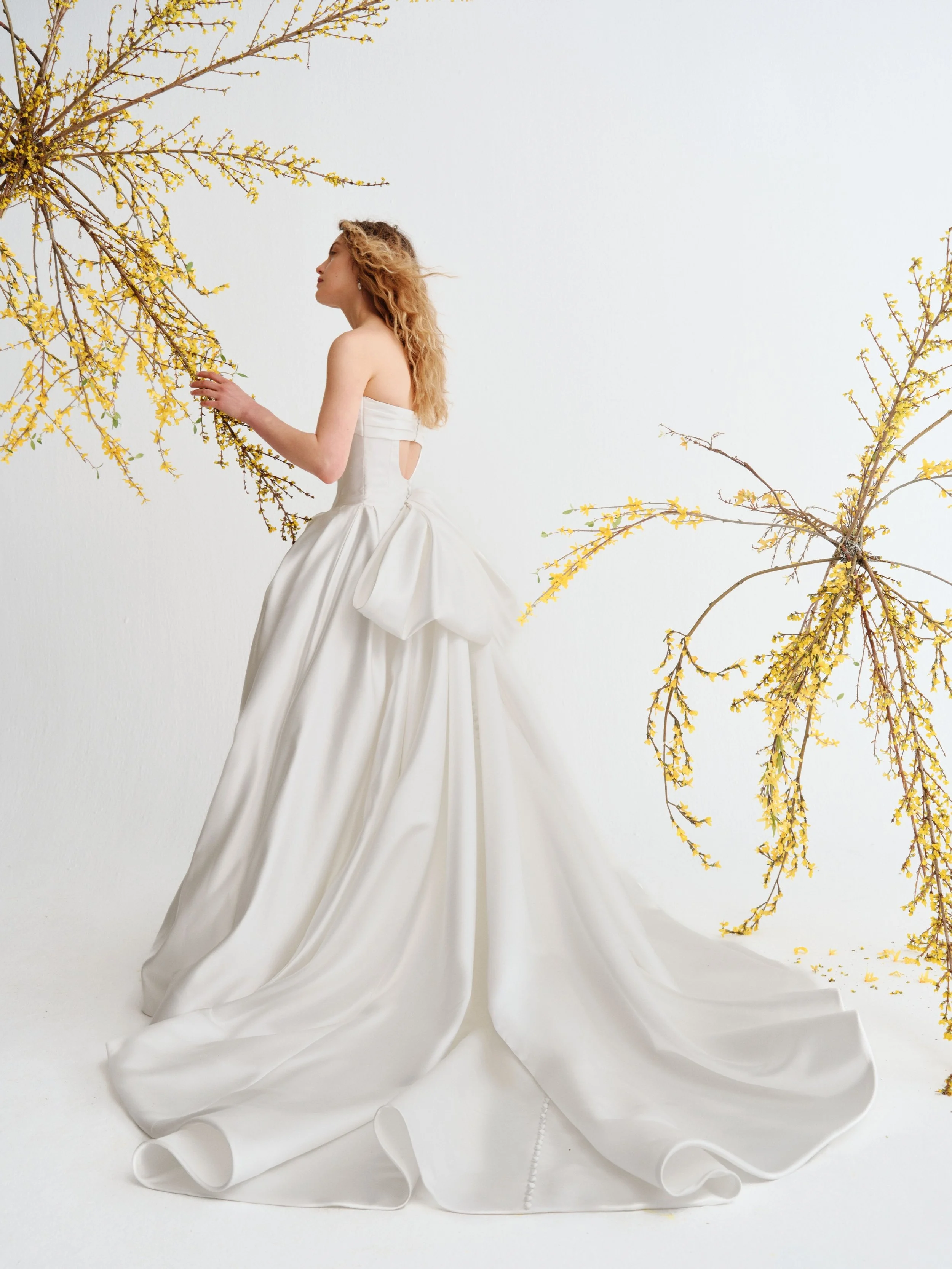 Meet REEVE 🤍 Grand satin ballgown with a strapless panelled bodice. The neckline is finished with a supple organically draped cuff. A voluminous skirt of lush folds. A grand double-looped bow at the open back, with satin button detail down the back.