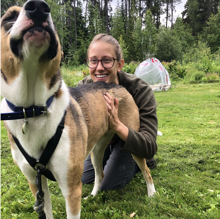 a woman hugging a dog outdoors