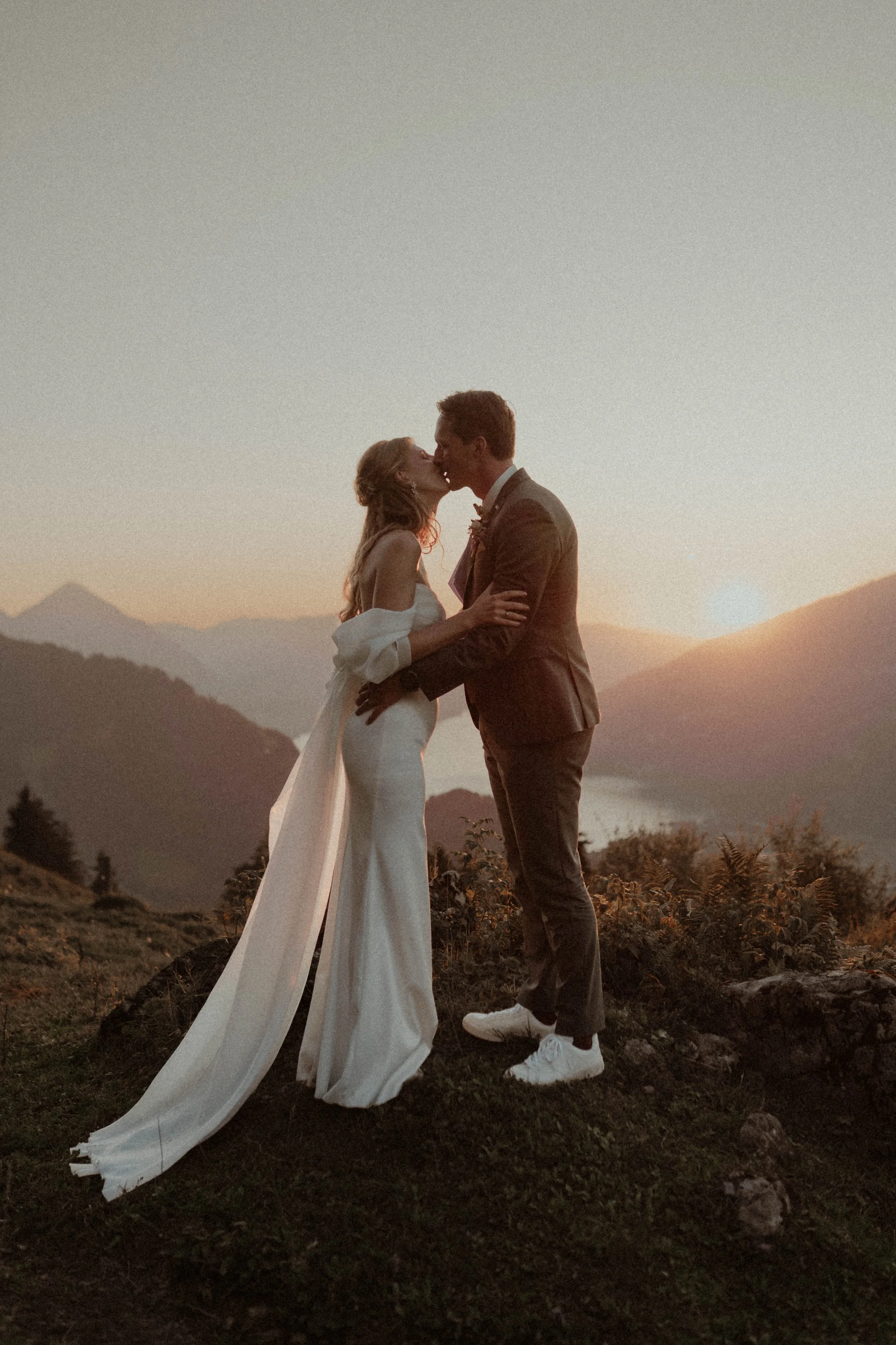 Brautpaar in den Schweizer Bergen bei Sonnenuntergang - cinematic Wedding Photograph Switzerland with natural und emotional mood