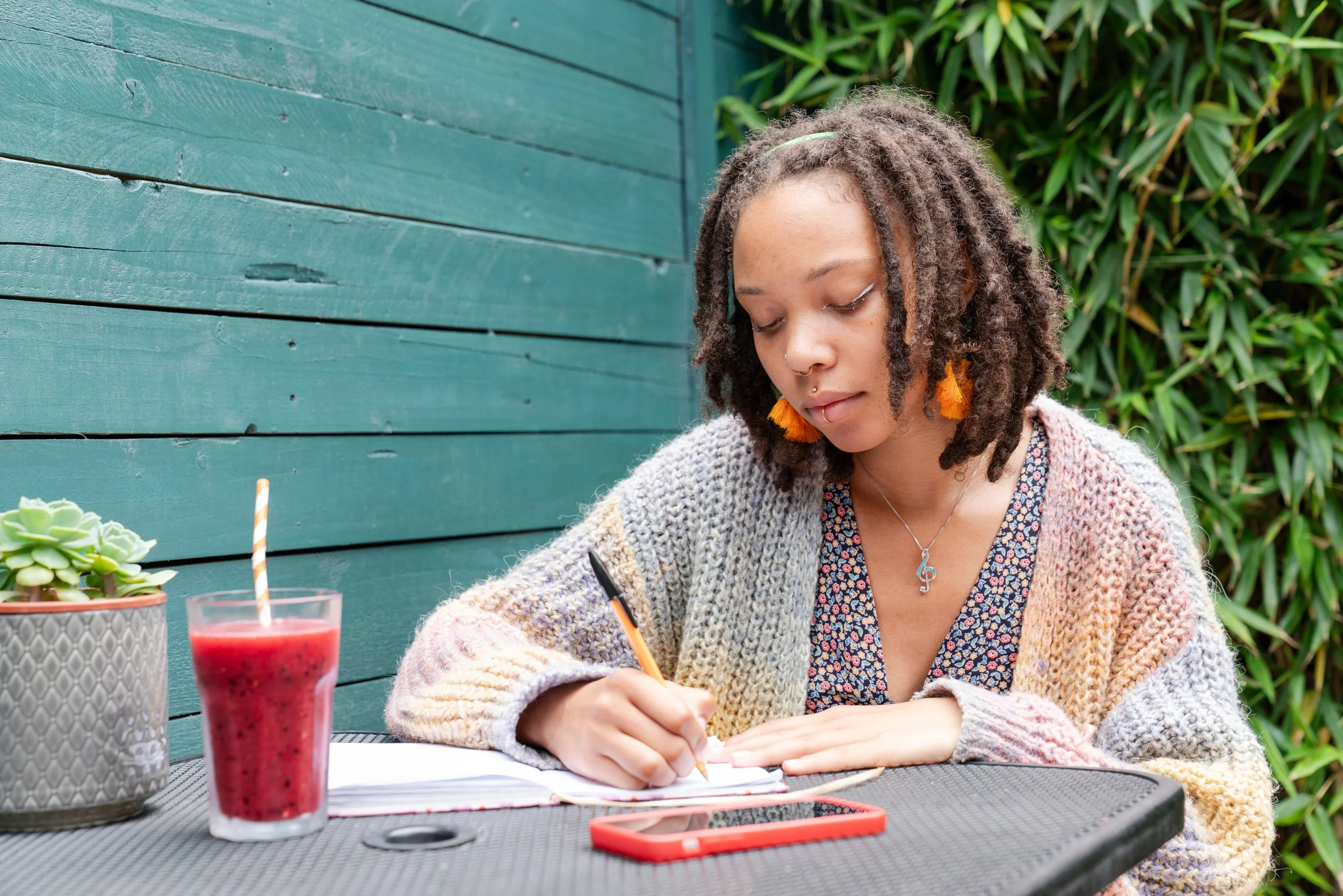 Woman sitting at a table writing in a notebook