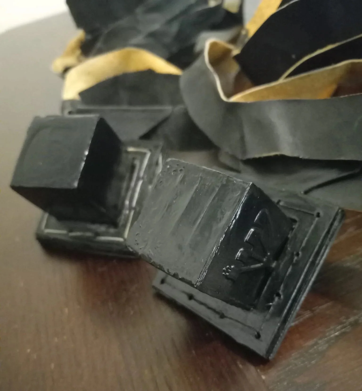 Close-up of a vintage black camera placed on a wooden surface with some cloth or fabric in the background.