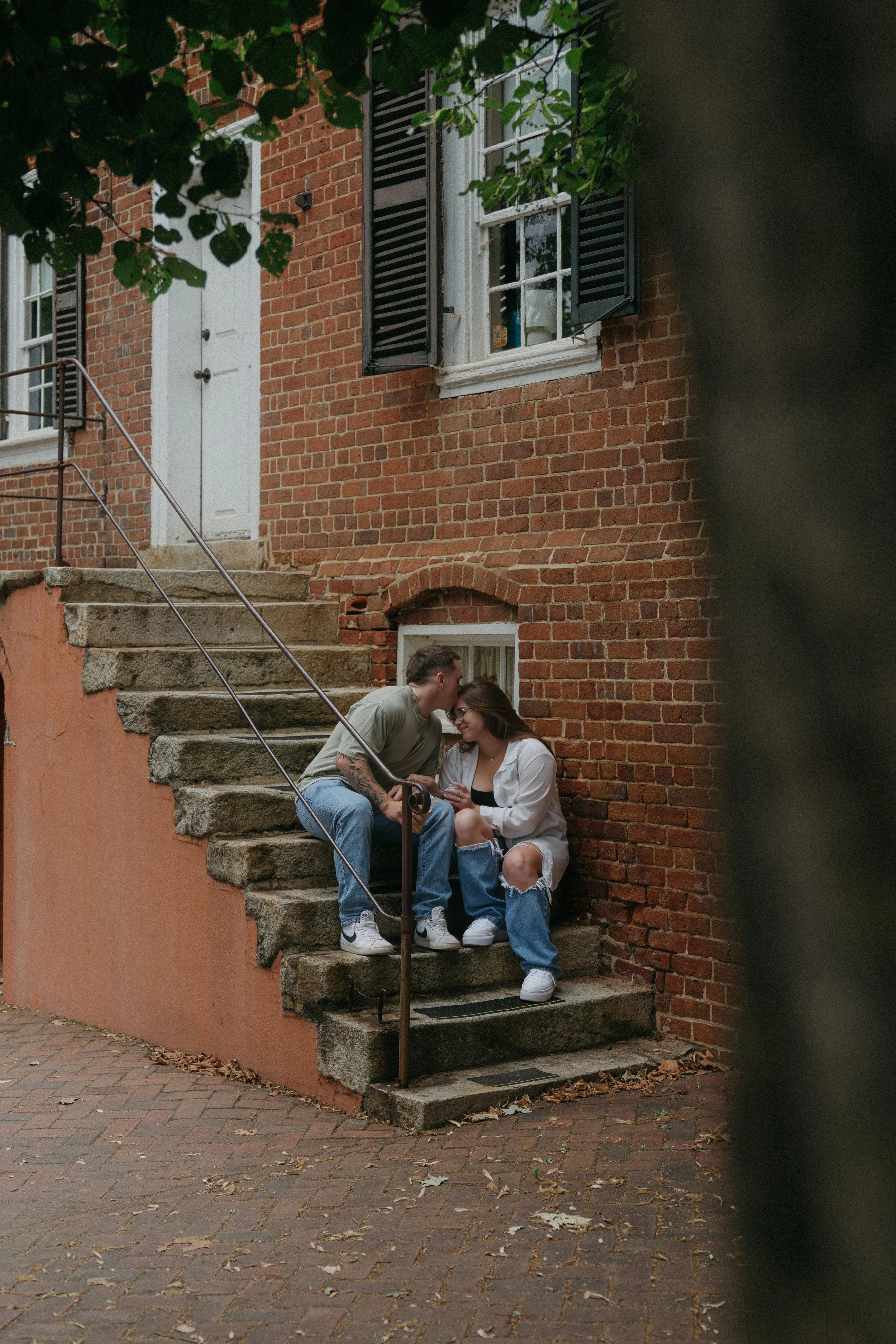 Couple sitting on brick steps in Old Salem historic district Winston-Salem NC