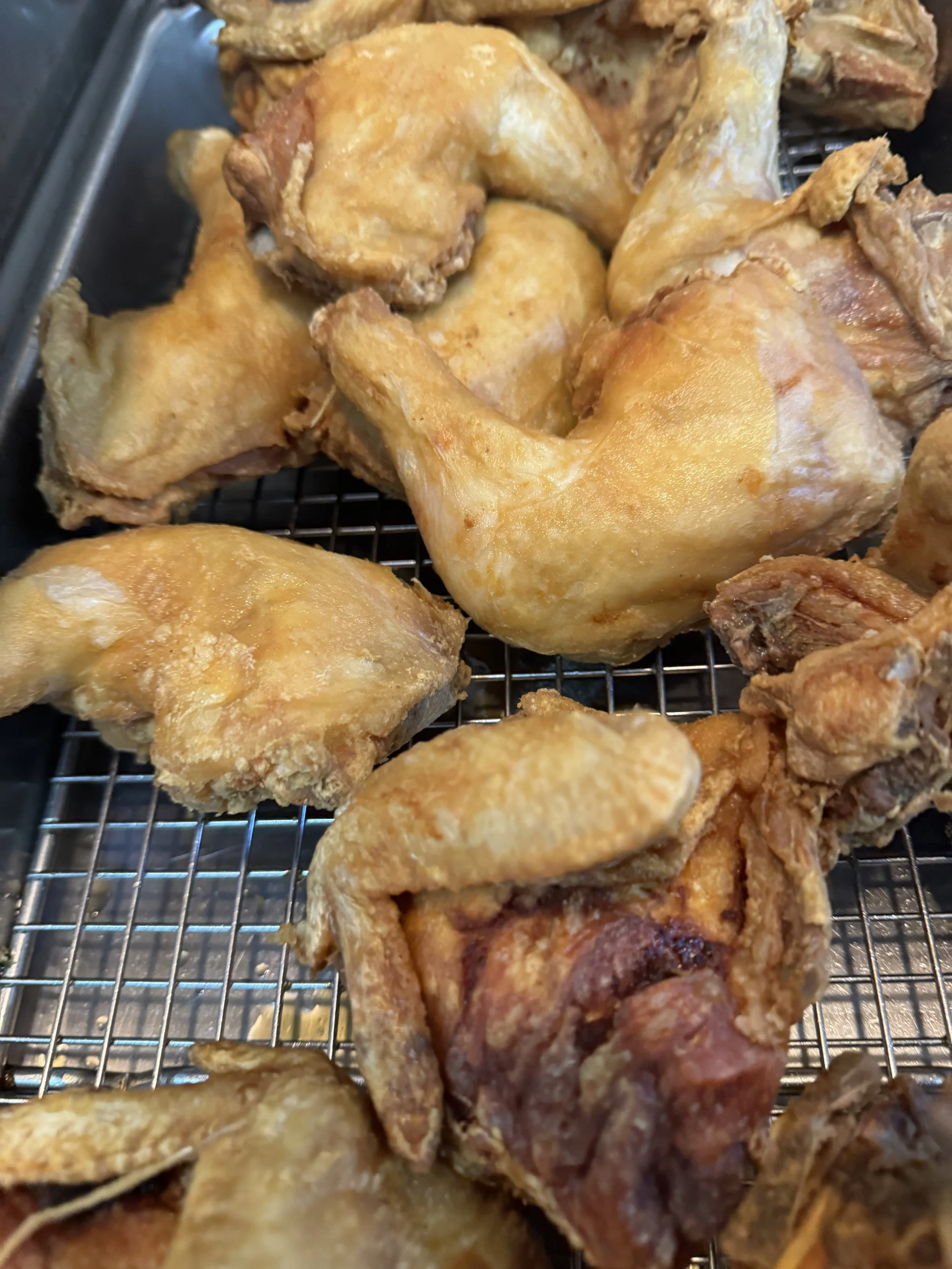 Fried chicken pieces on a wire rack.