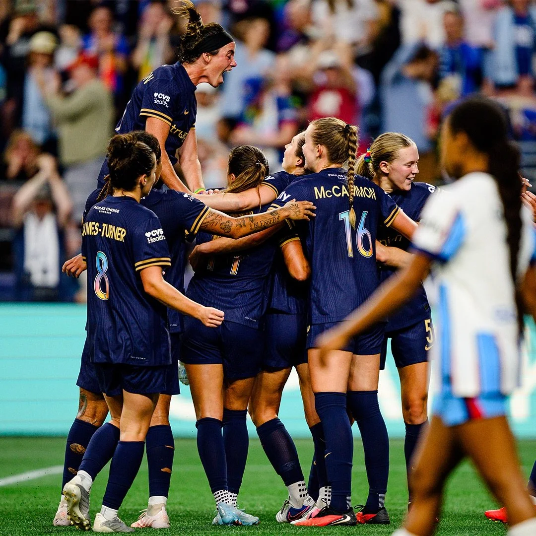 Reign FC team celebrating a goal at Lumen Field