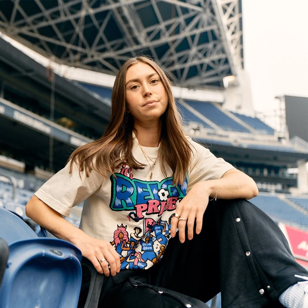 Maddie Mercado in the stands at Lumen Field wearing a pride t shirtr