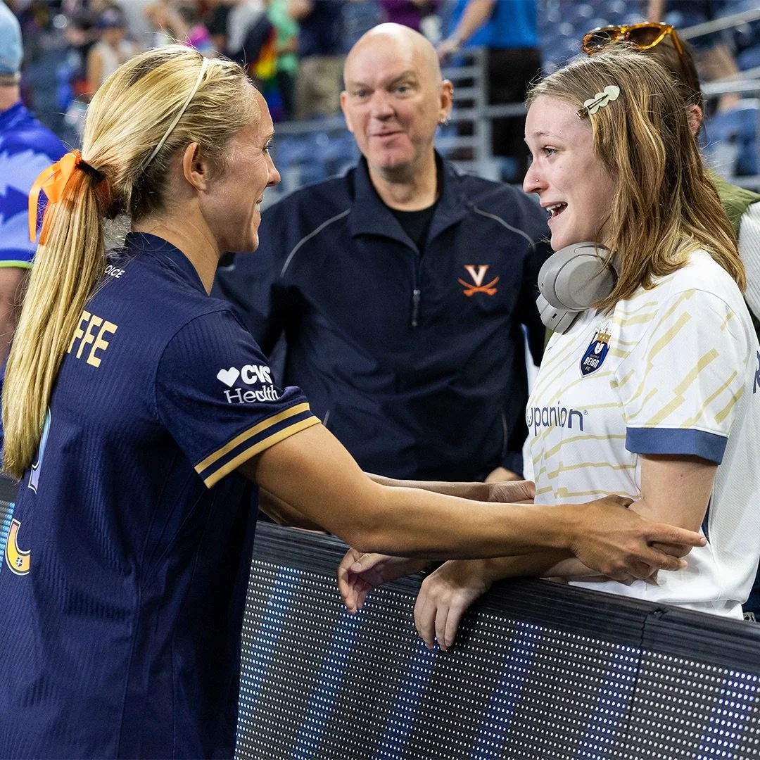 Brittany Ratcliffe interacting with a fan pitchside