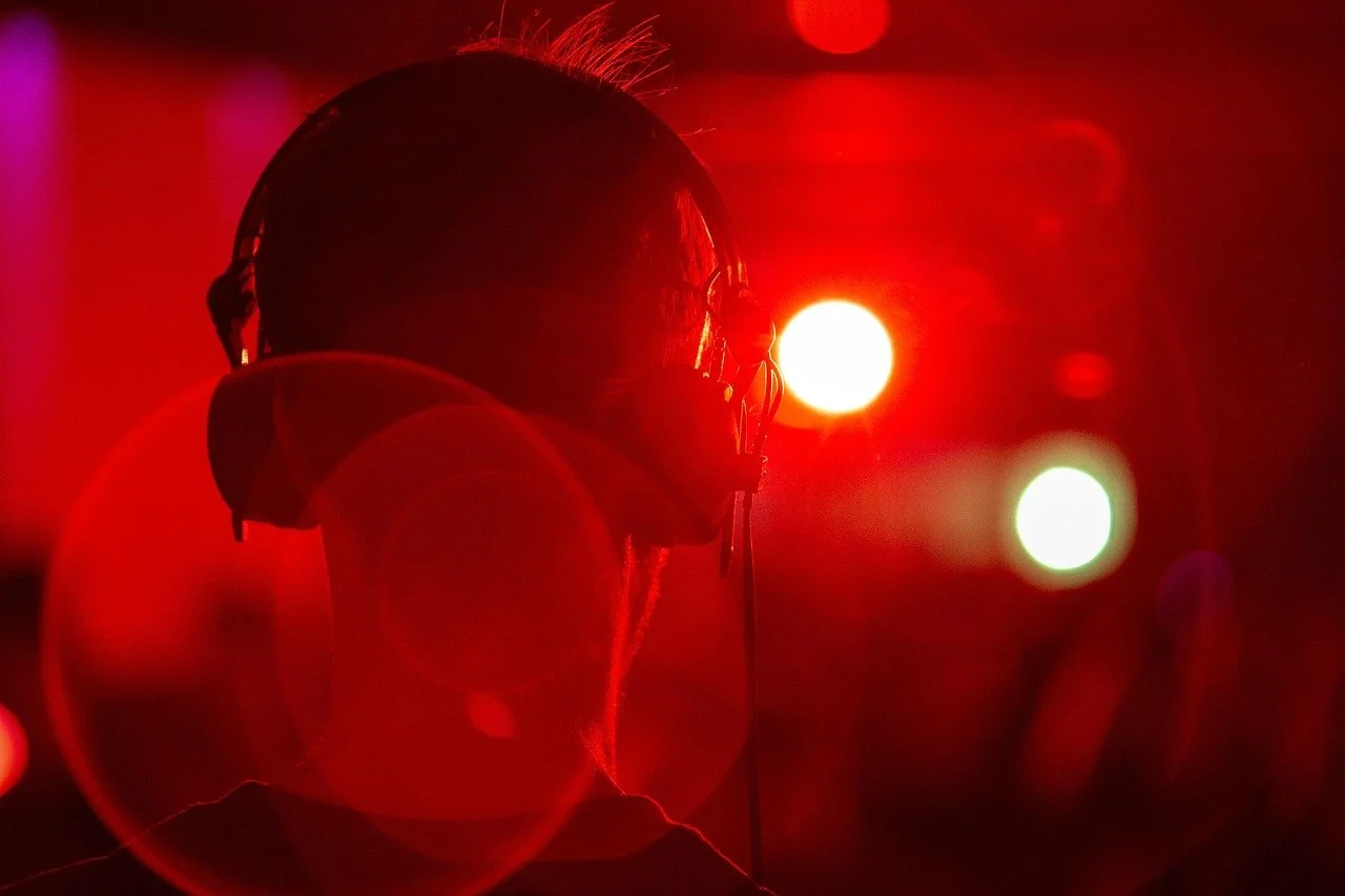 Man in a room with red lights wearing headphones.