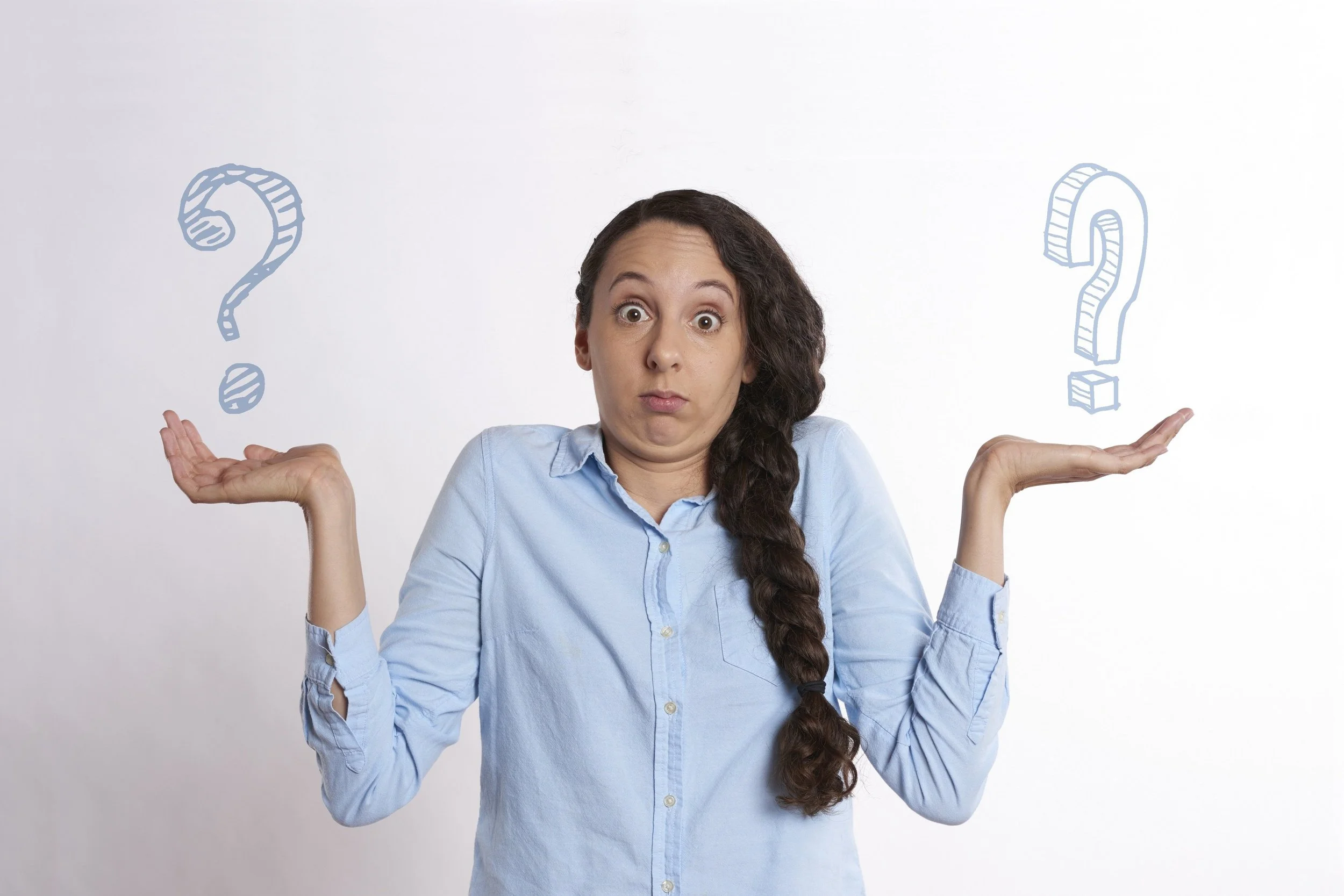A woman shrugging and holding two question marks
