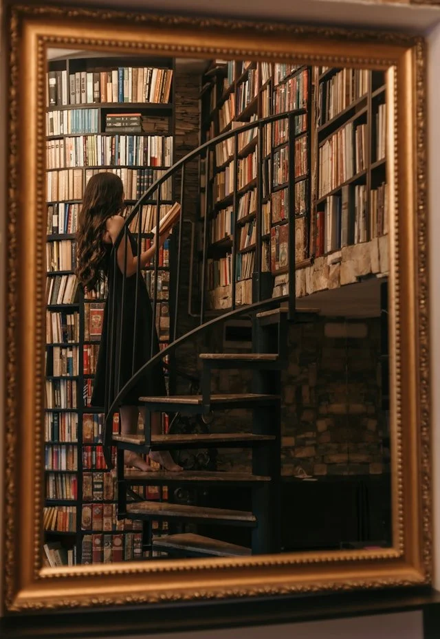 femme lisant un livre dans les escaliers d'une bibliothèque
