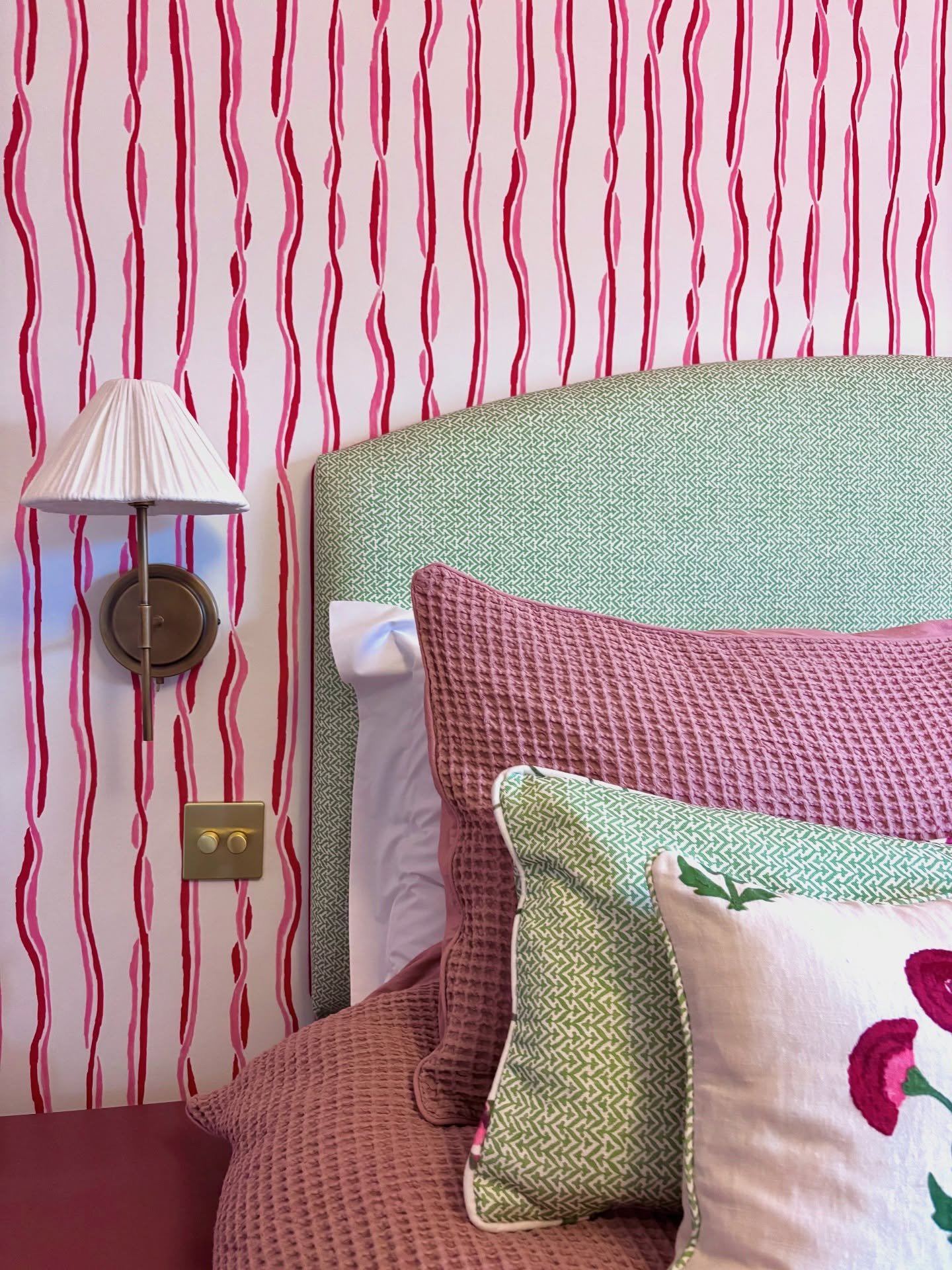 Previously we talked about the power of texture in design, now here&rsquo;s how different textures can come together beautifully. From fabric green headboard with a red trim, to textured wall lamps and a mixture of pillows, every material adds depth 