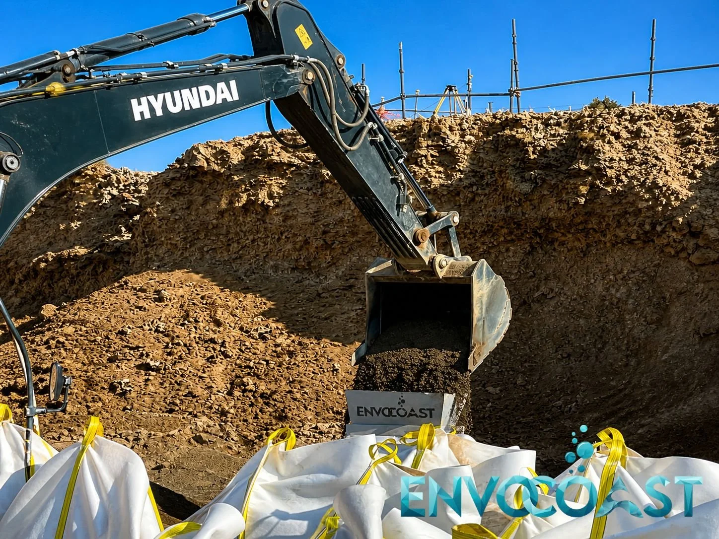 Excavator loading soil into geobags for coastal protection operations by Envocoast in KSA
